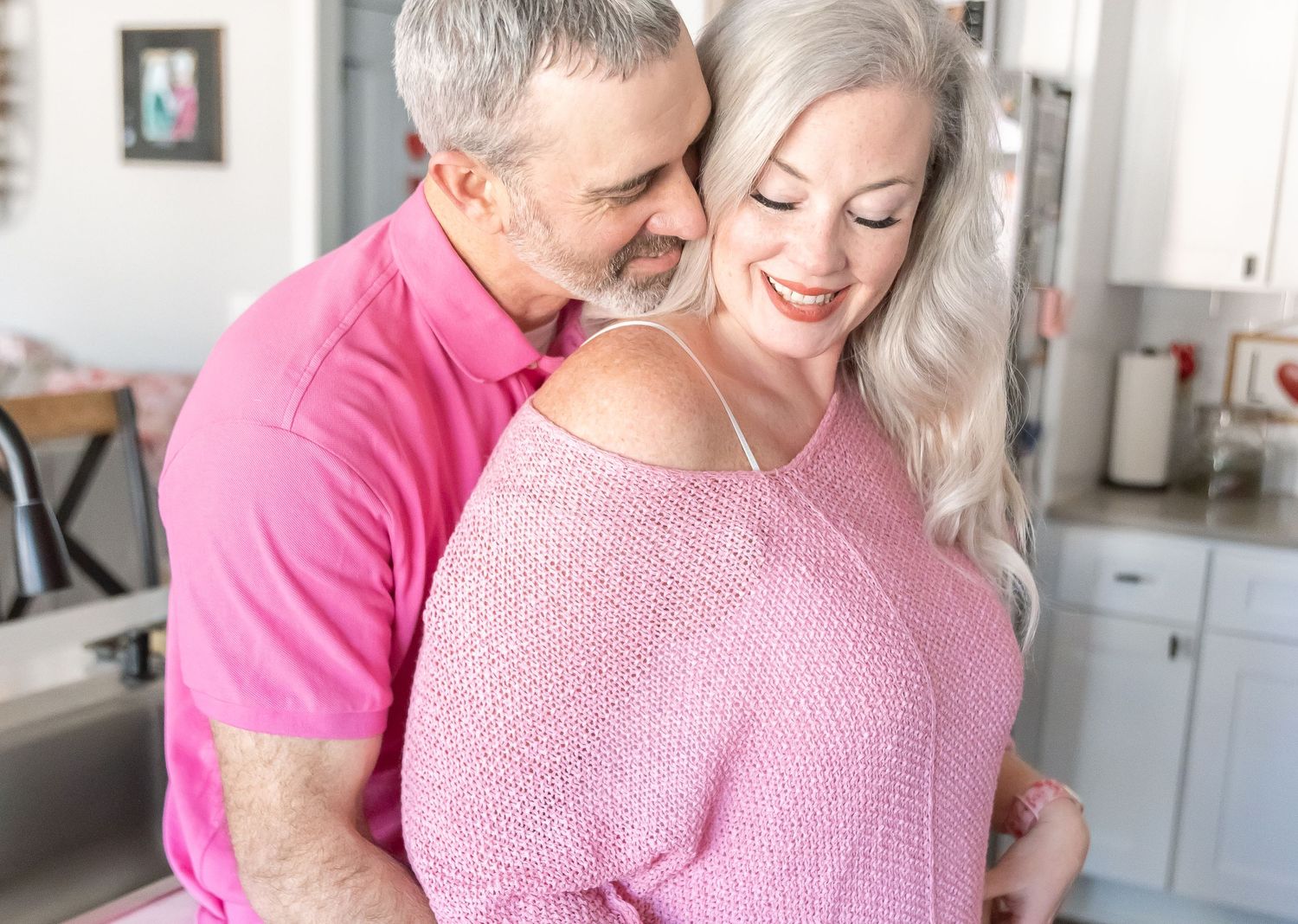 A romantic moment shared in a kitchen decorated with holiday wreaths and decorations.