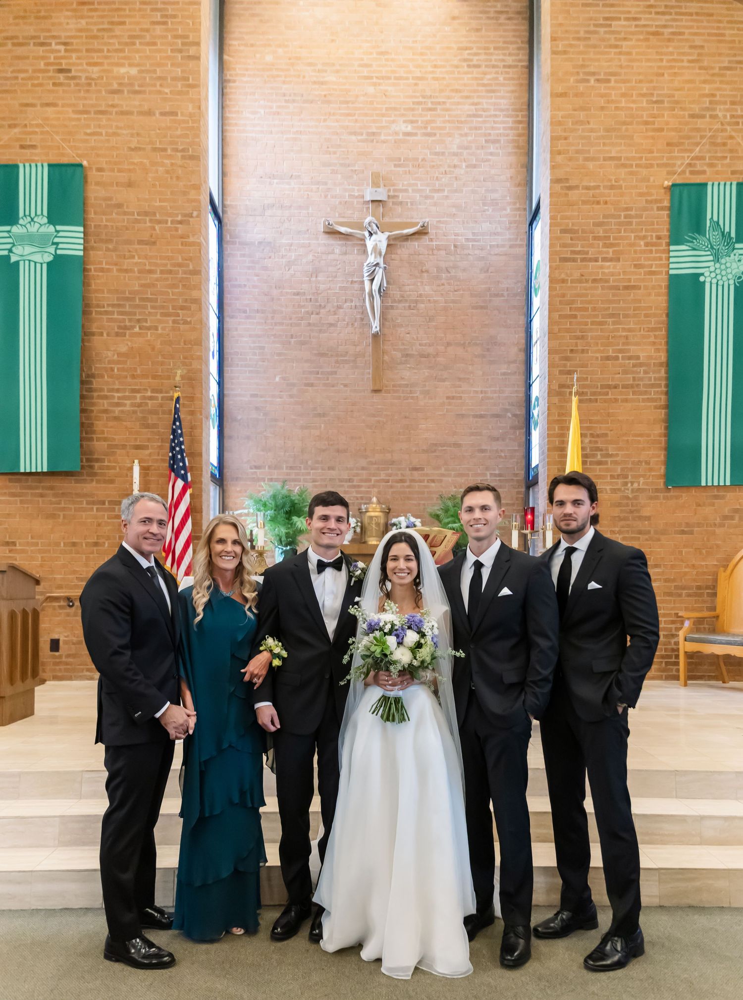 Wedding party poses in church sanctuary with crosses and religious symbols in background.
