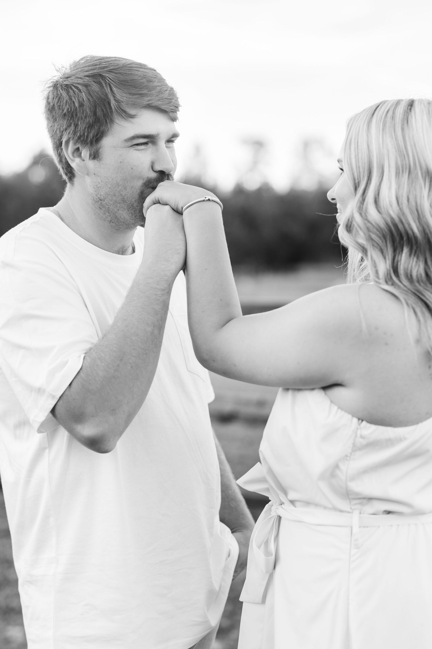 A sweet black and white photo of a couple sharing an intimate moment outdoors.