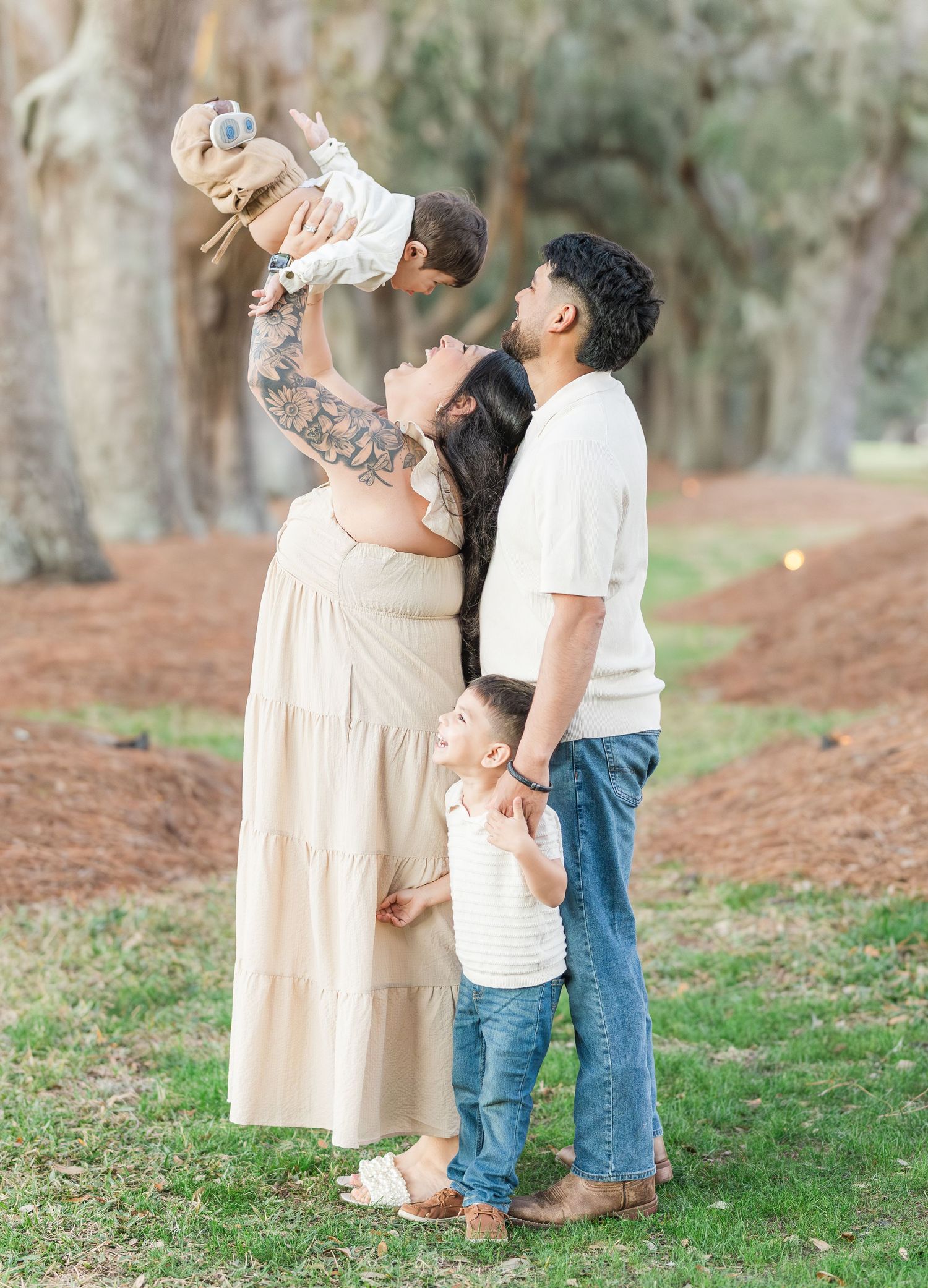Joyful family interaction captured in a series of candid moments on a grassy slope with trees in background.