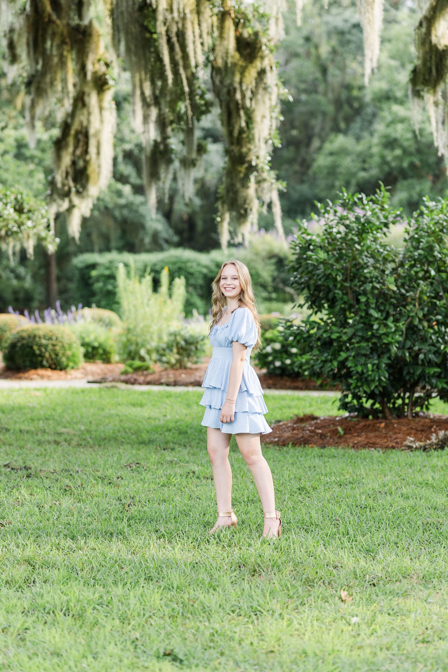 Light summer dress against Spanish moss and lush garden scenery in outdoor portrait setting.