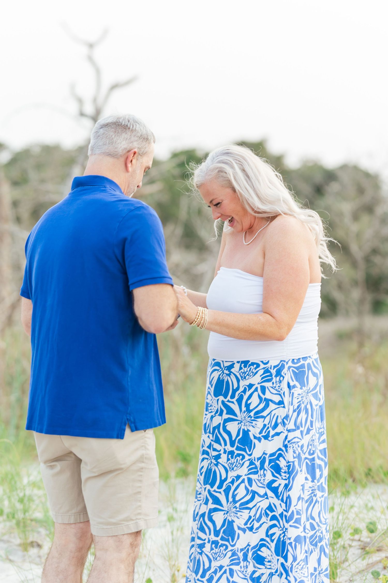 A romantic proposal scene on the beach as a couple shares an intimate moment.