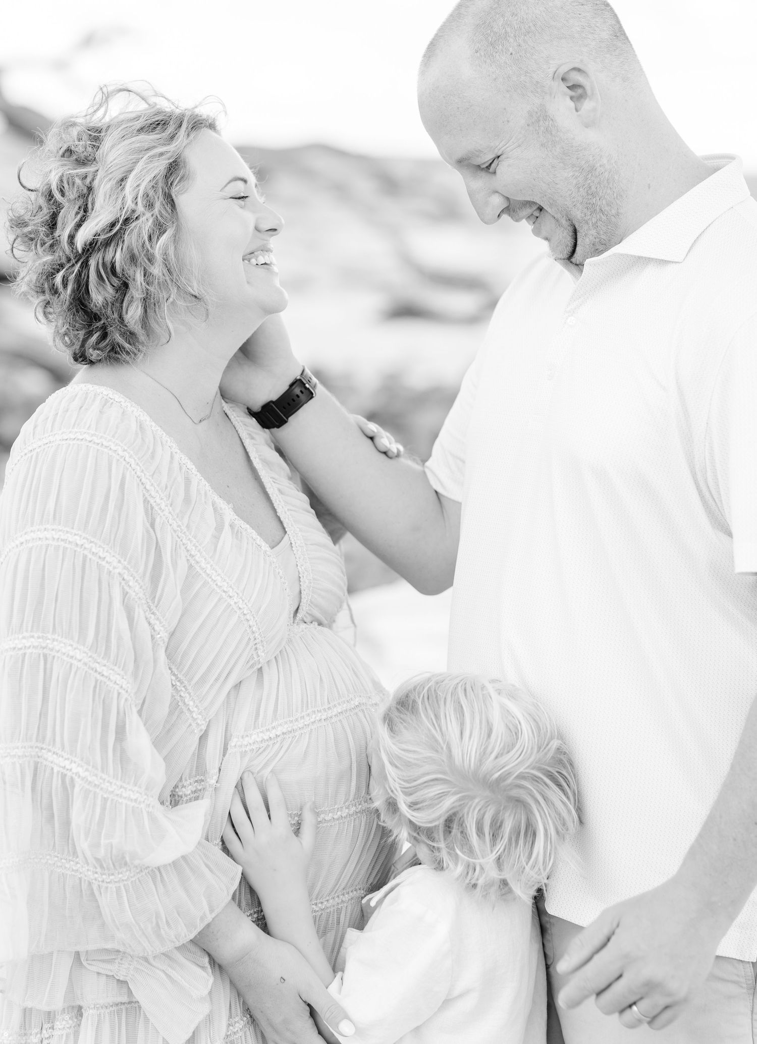 Intimate beach photo session in white and cream tones showing loving family moments.