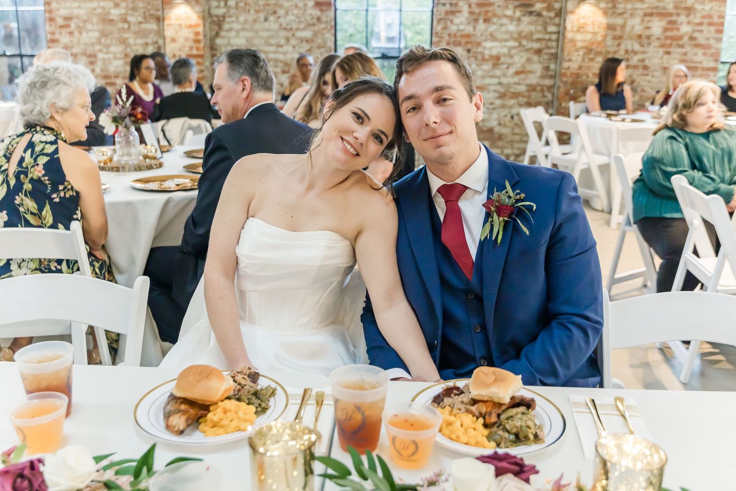 Wedding reception dining scene with table settings in a rustic brick venue.
