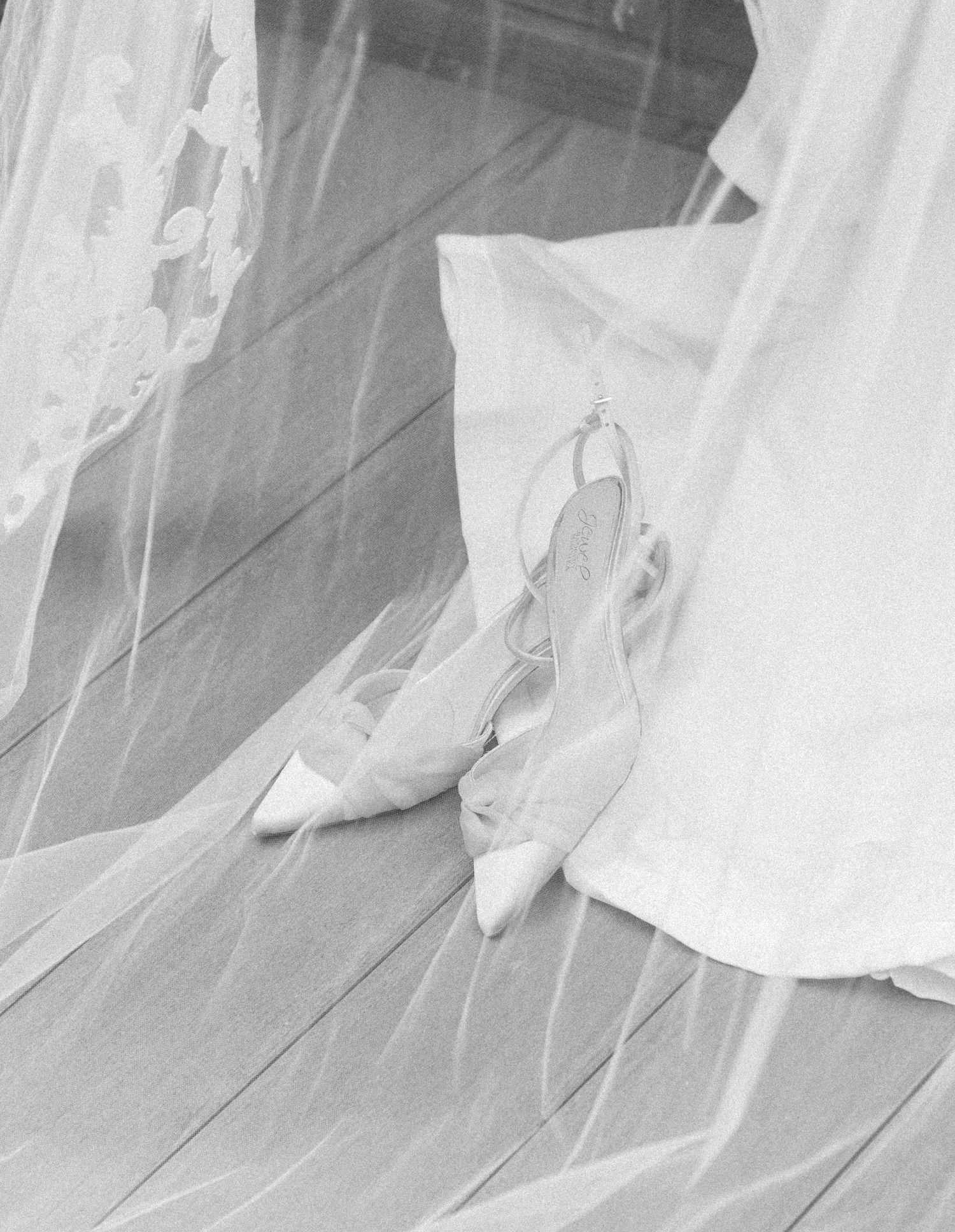 Flowing white wedding veil fabric draped gracefully across a light colored floor.