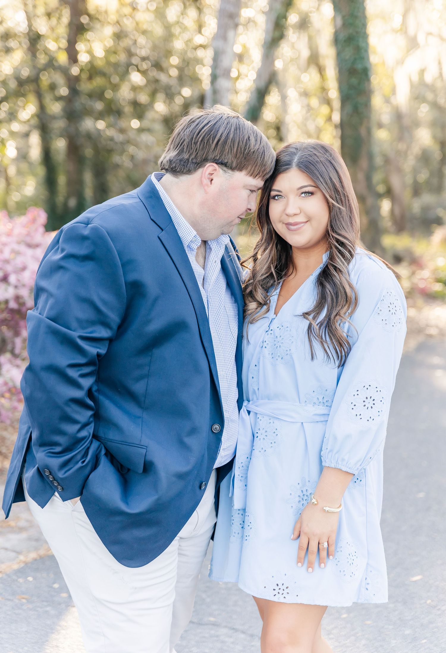 An intimate portrait of a couple in matching blue attire sharing a close moment on a garden path.