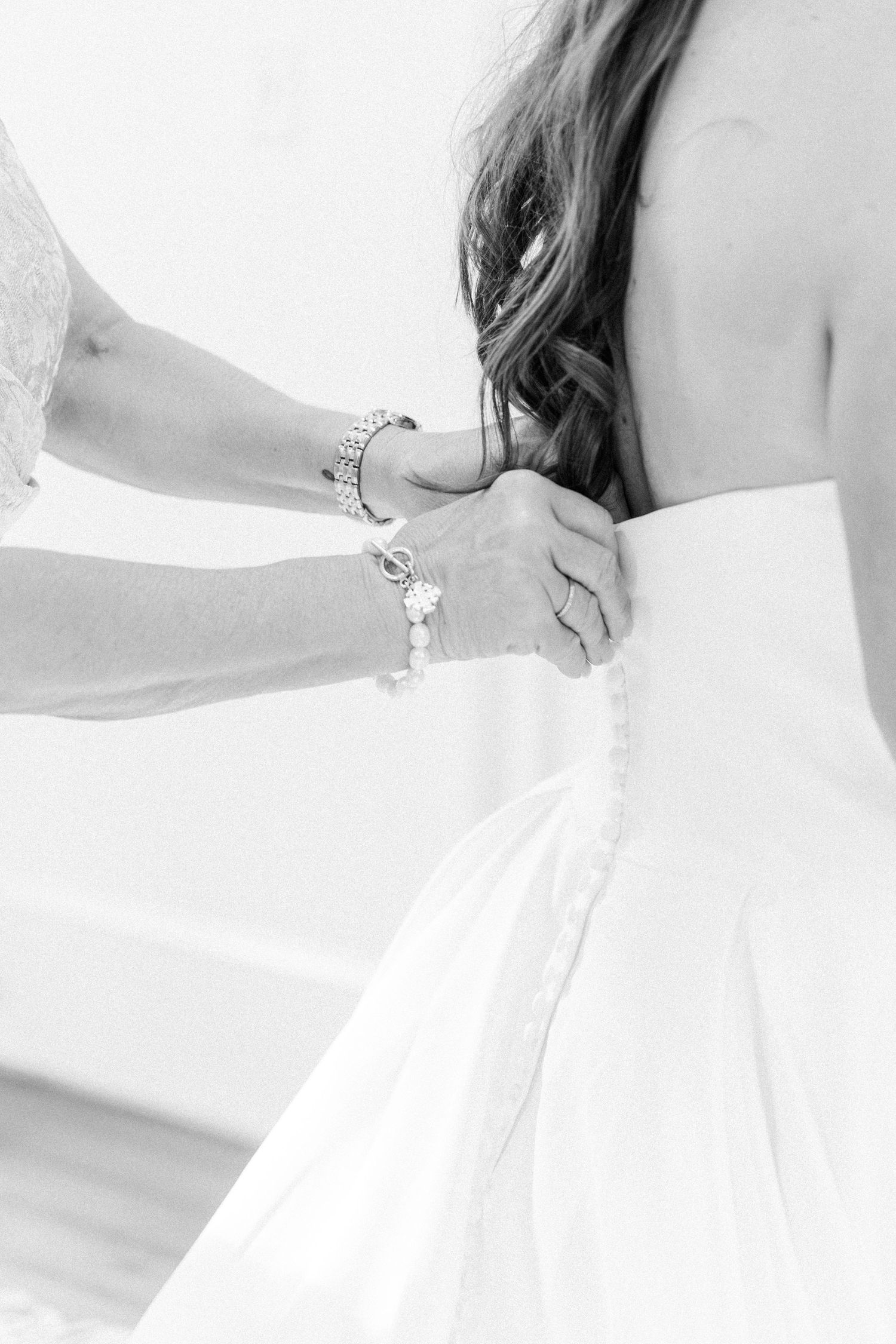 Elegant white wedding dress with lace details shown in a series of close-up shots highlighting the delicate fabric.