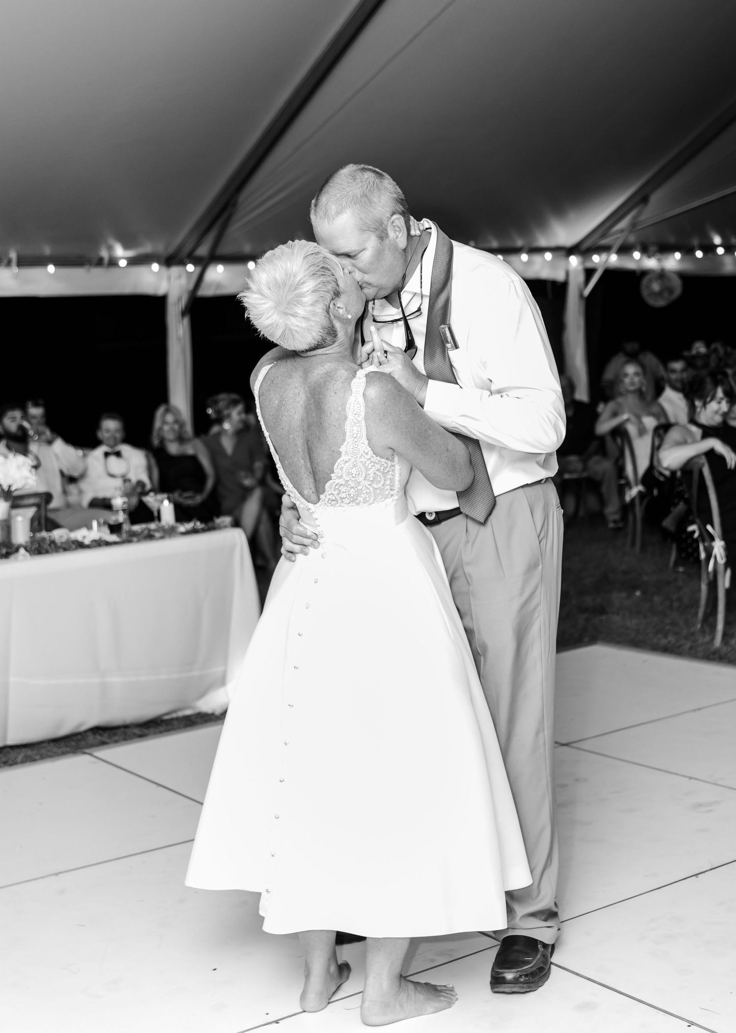 Black and white photos show couples dancing during a wedding reception under a tent.
