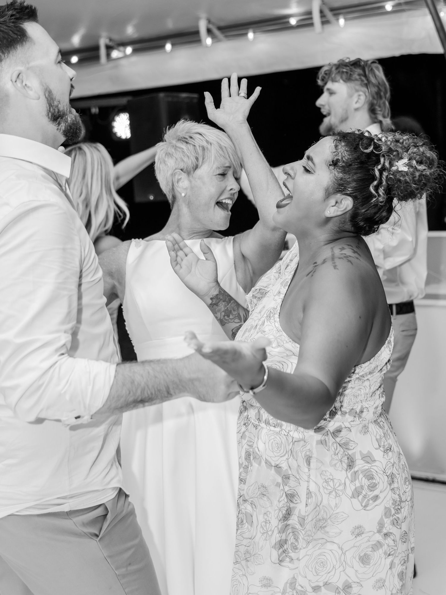 Black and white sequence of four photos showing a couple sharing a playful and joyful moment during their wedding dance.