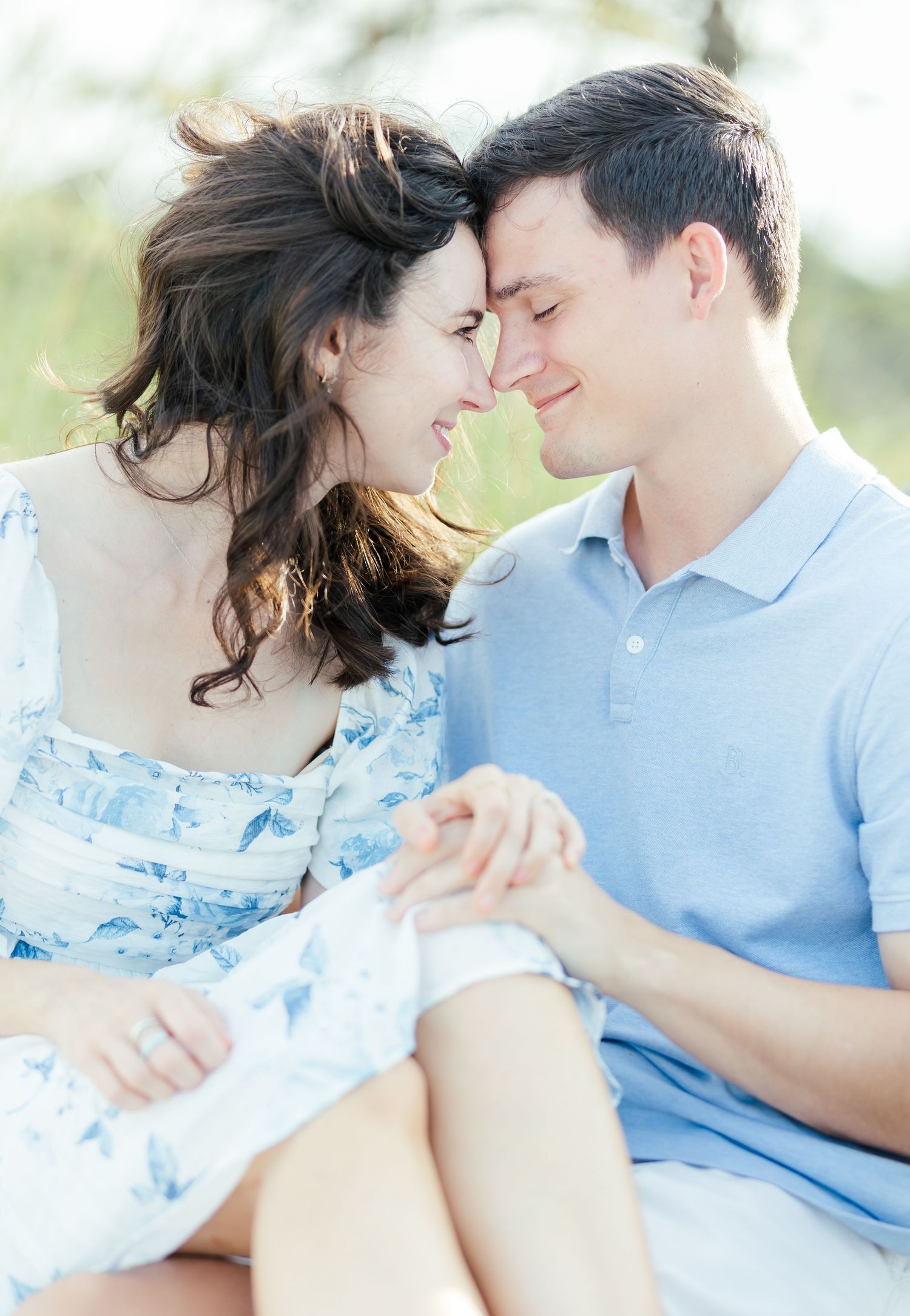 Couple in matching light blue attire sharing intimate moments against a soft dreamy background.