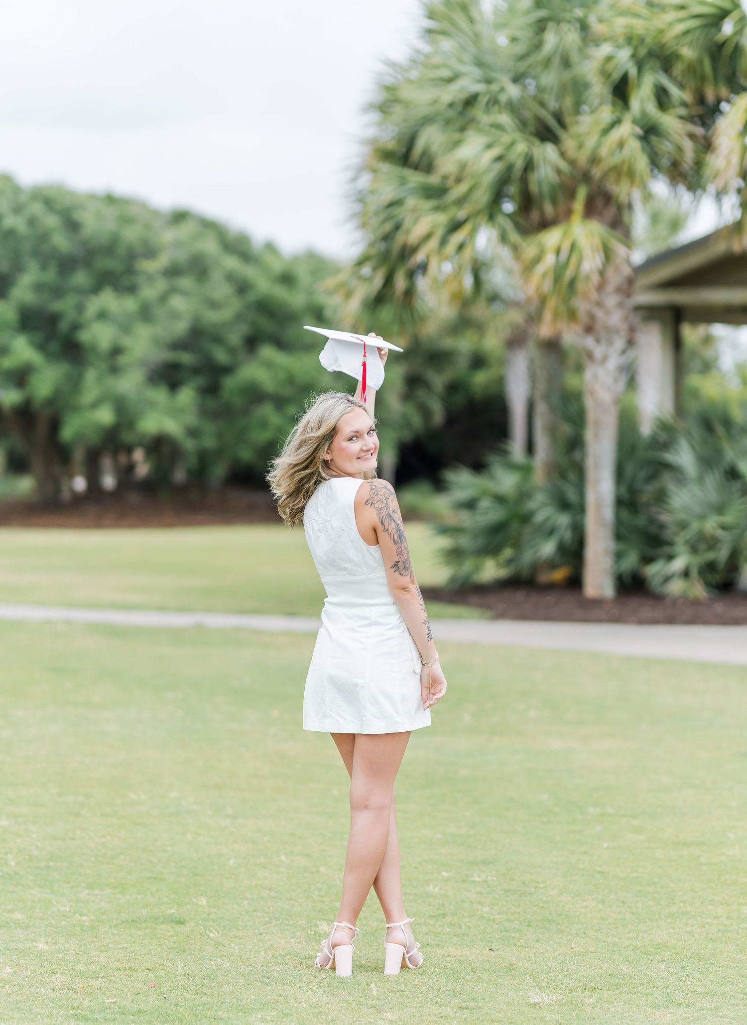 A series of photos showing a child wearing a white dress playing and running in a sunny park with palm trees.