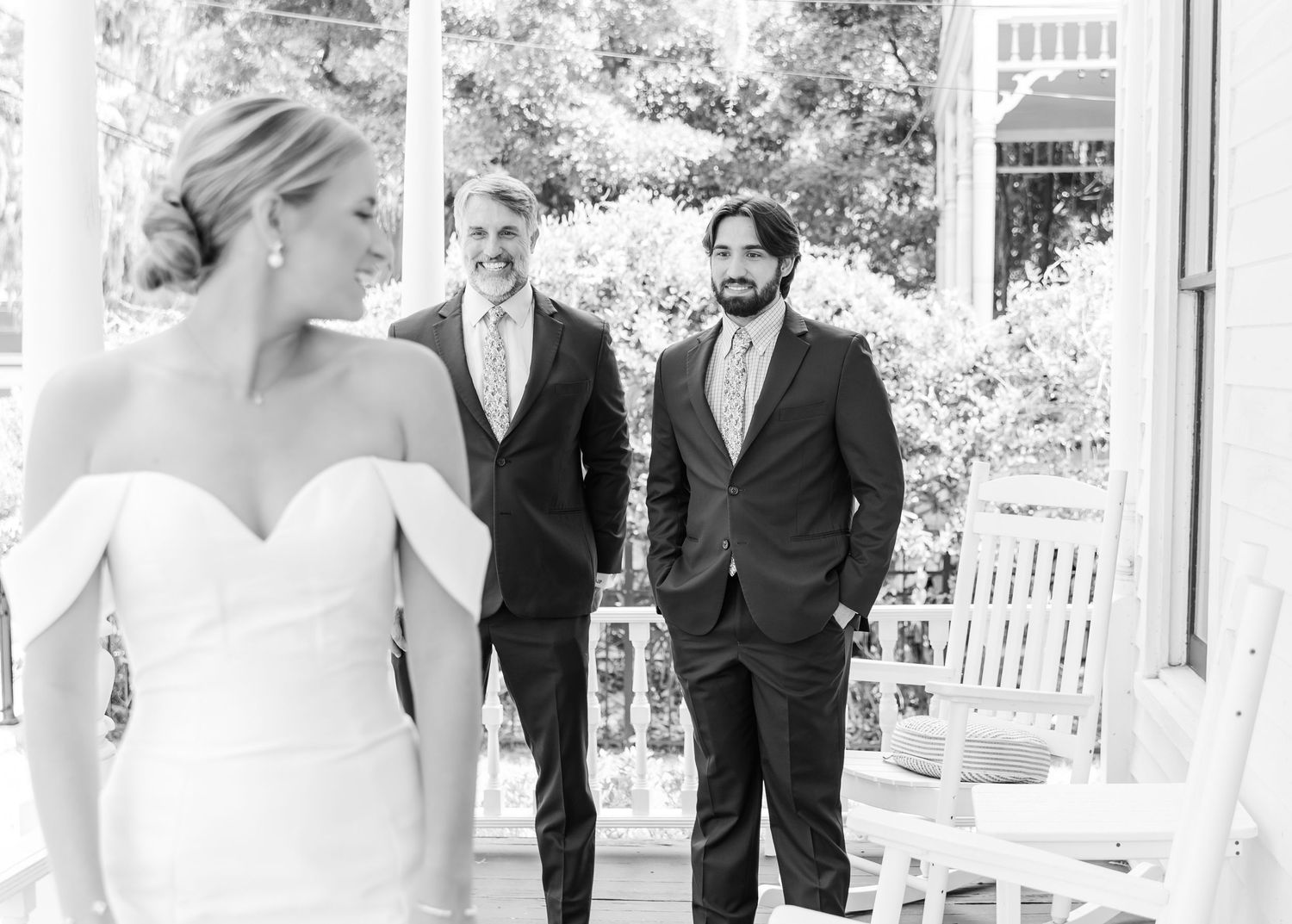 Wedding party walking and laughing together on outdoor patio during sunny celebration.