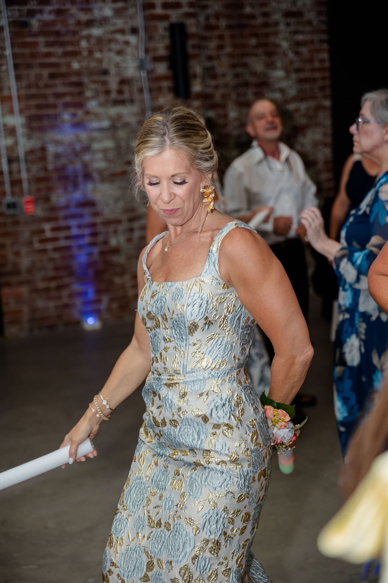 Dancers in shimmering formal attire move energetically on the reception dance floor.