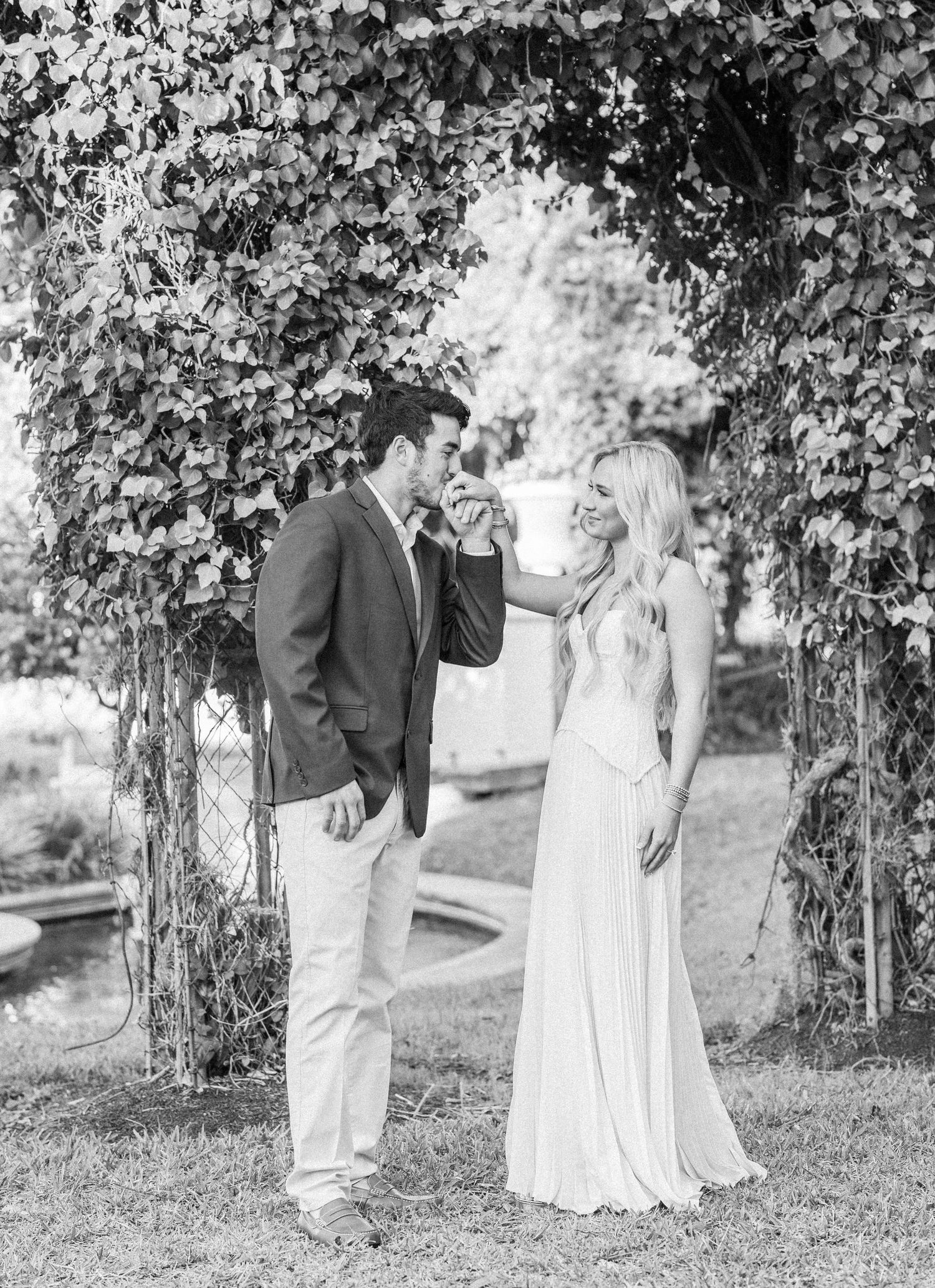 A series of romantic black and white photos showing a couple dancing and twirling under tree branches.