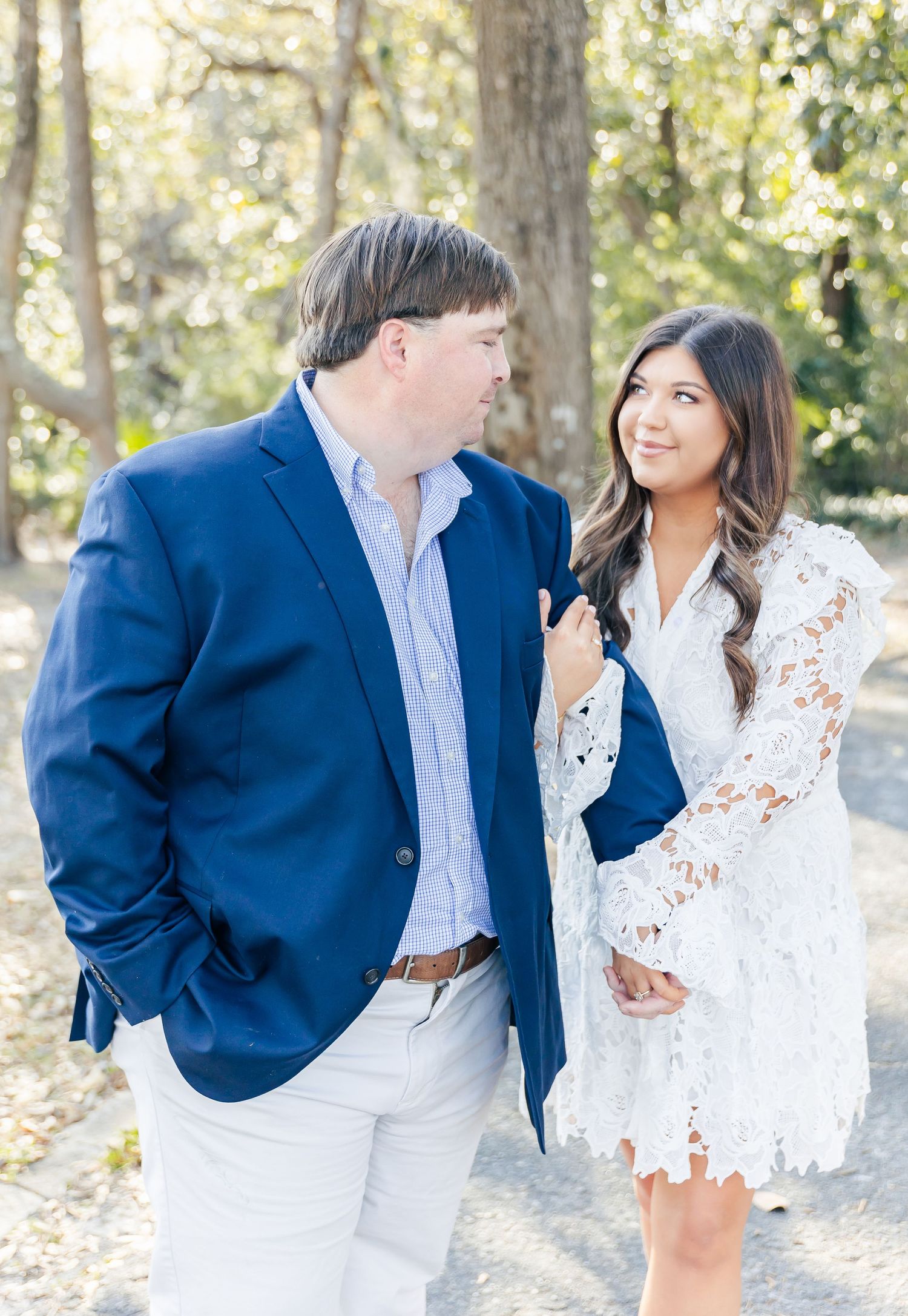 A romantic couple in coordinating navy and white outfits share intimate moments during an autumn outdoor photo session.