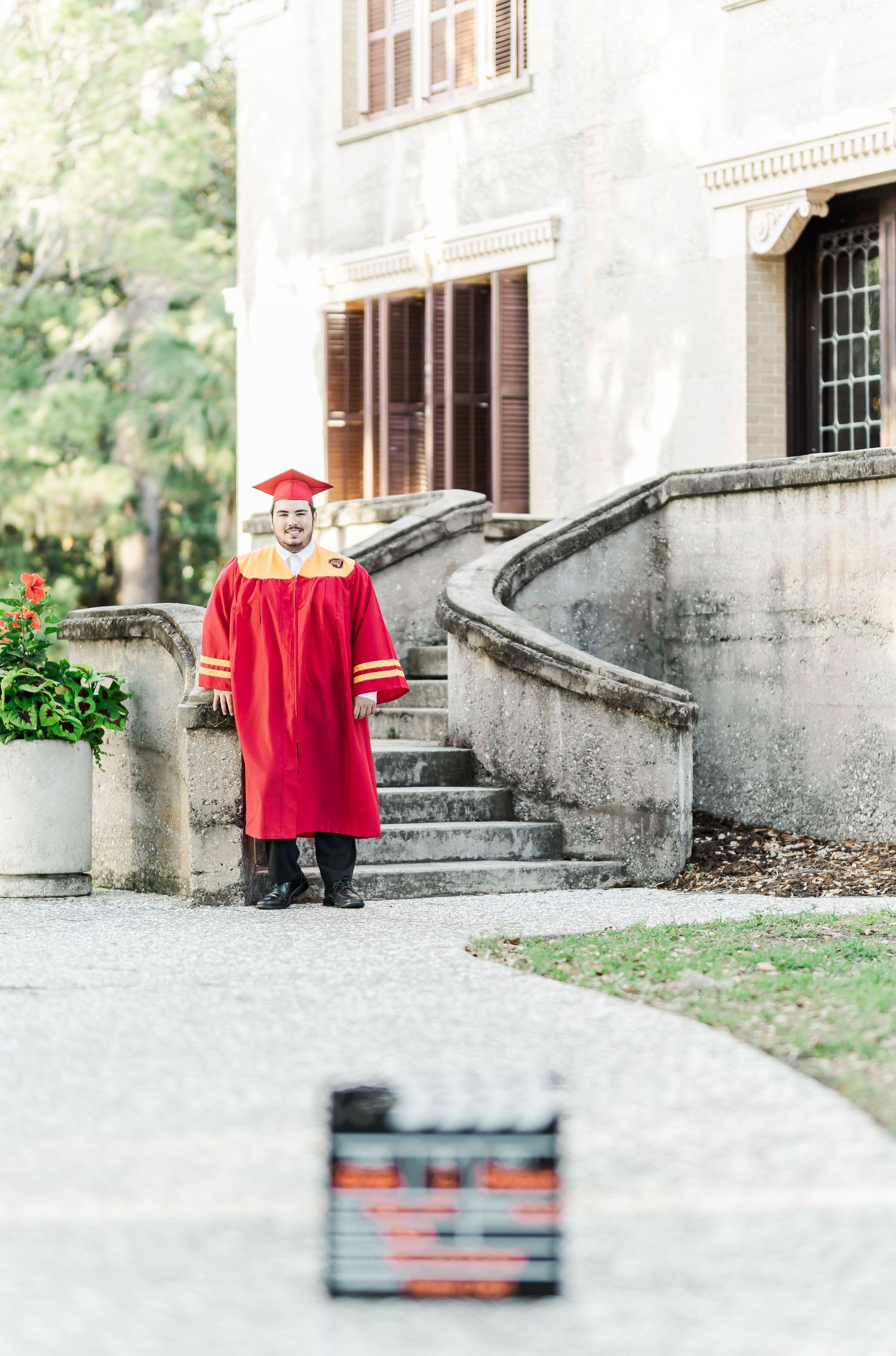 A series of outdoor portrait shots featuring a bright red sweater against a stone architectural backdrop.