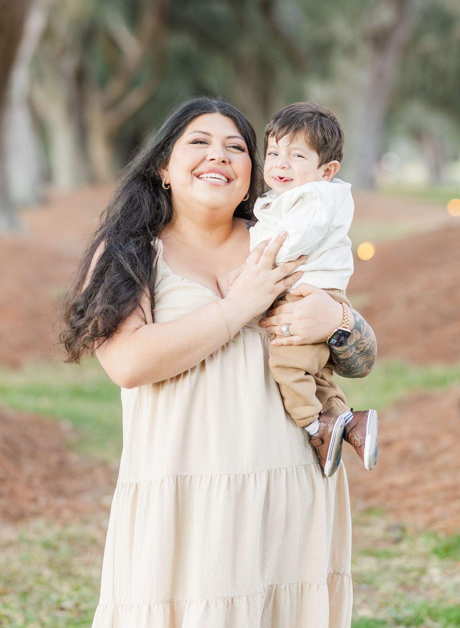 Joyful family portraits showing affectionate moments in a natural outdoor setting with trees.