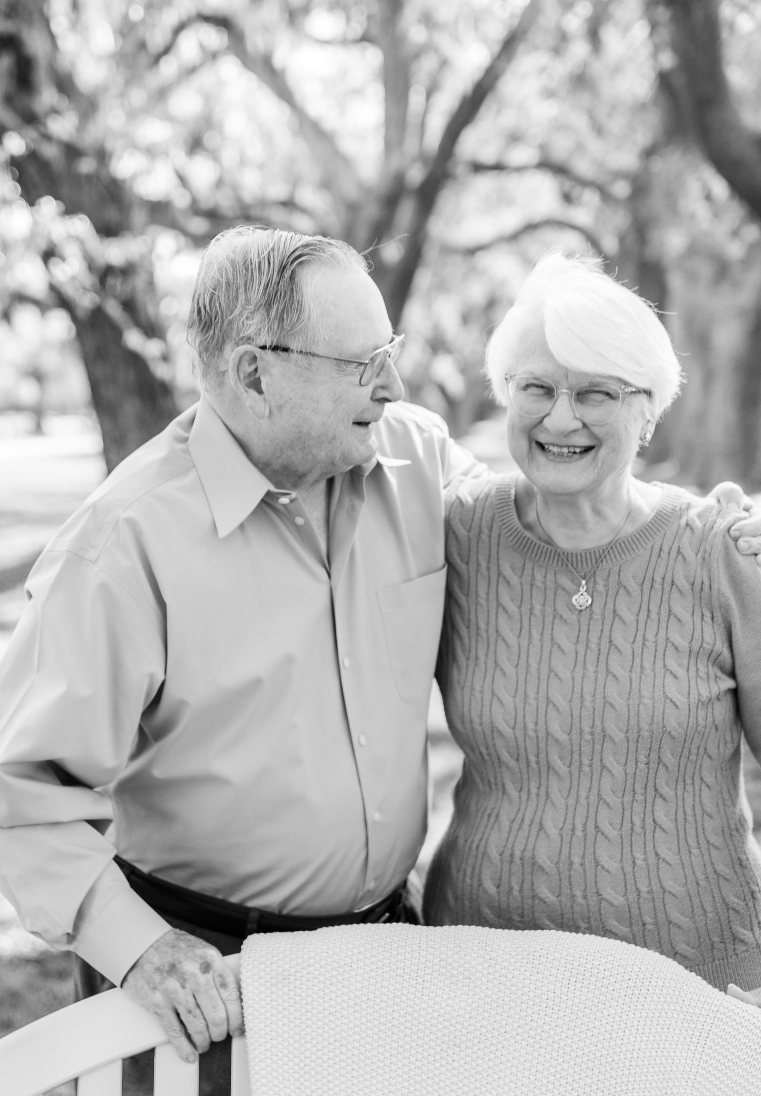 Black and white portrait of senior couple sharing tender moment outdoors.
