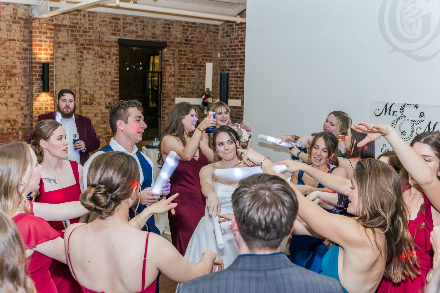 Wedding guests raising champagne glasses in a toast during reception celebration.