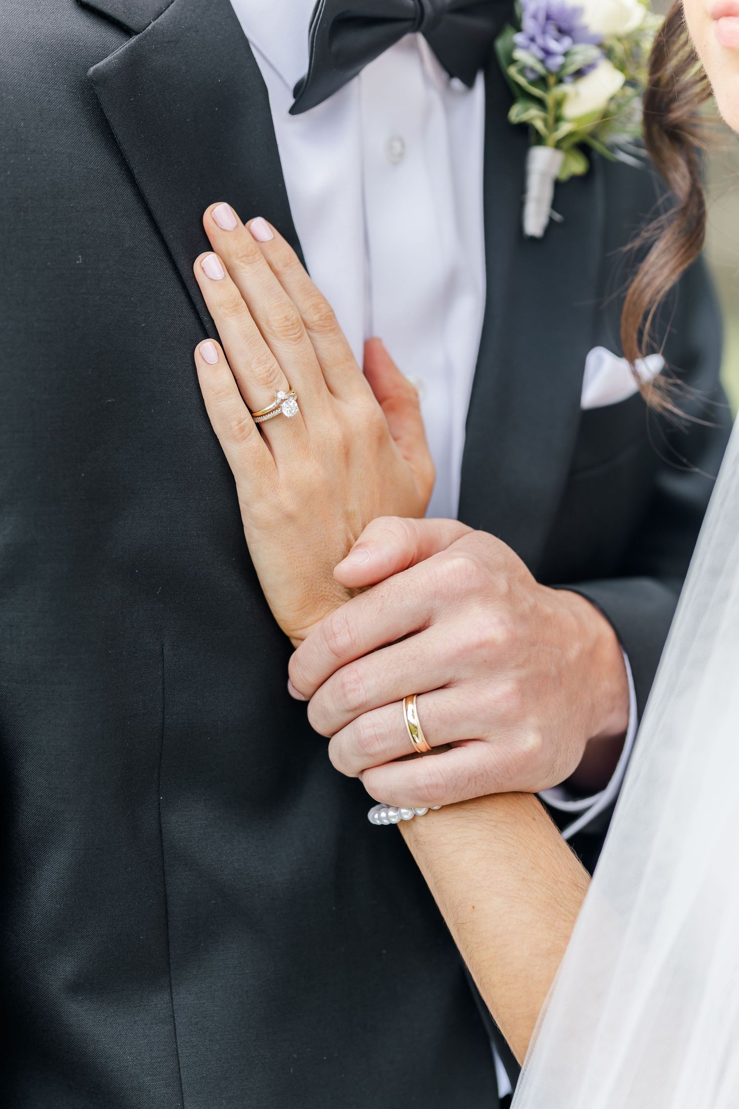 Close up of wedding rings and hands as couple shows their new jewelry.
