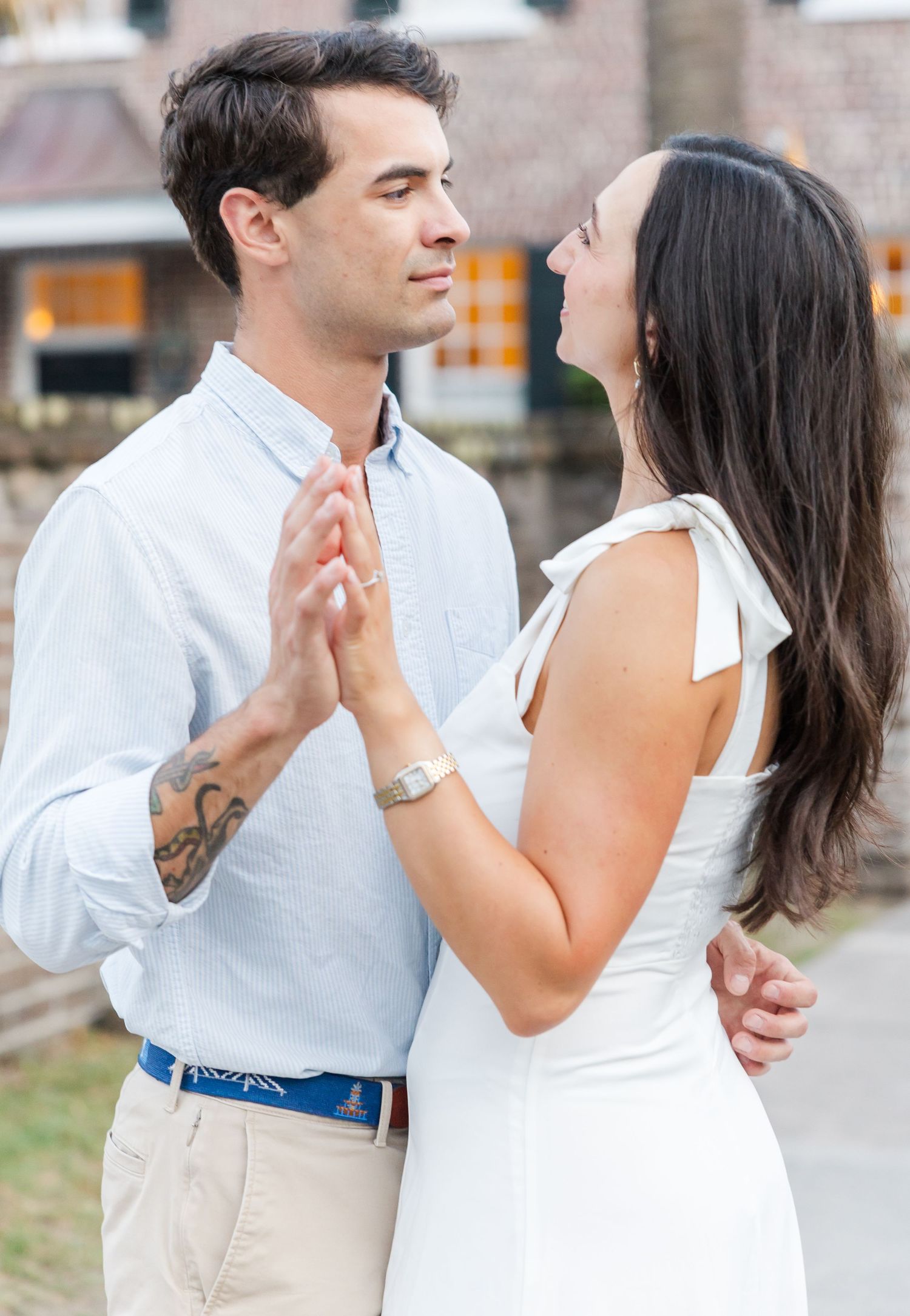 Engaged couple holding hands and gazing at each other lovingly during an outdoor engagement photo session.
