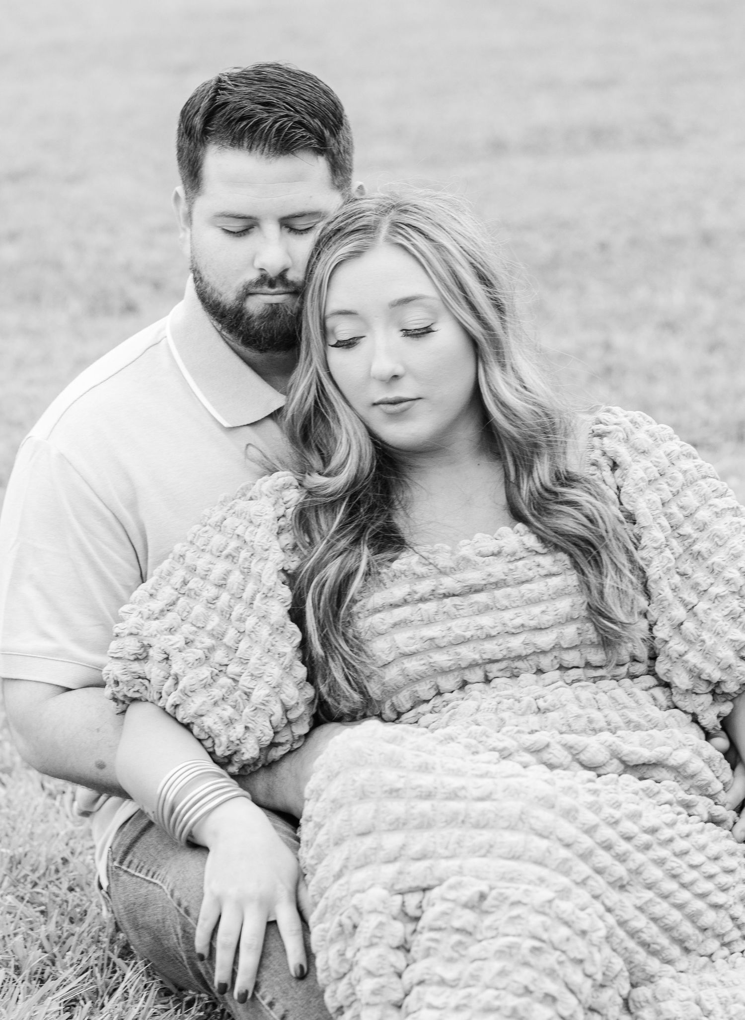A series of intimate black and white portraits showing tender moments in a natural outdoor setting.