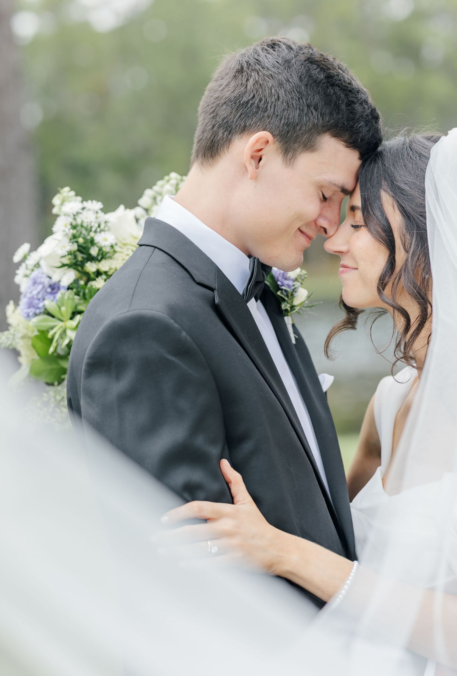 Intimate wedding portraits showing tender moments between couple through sheer veil.
