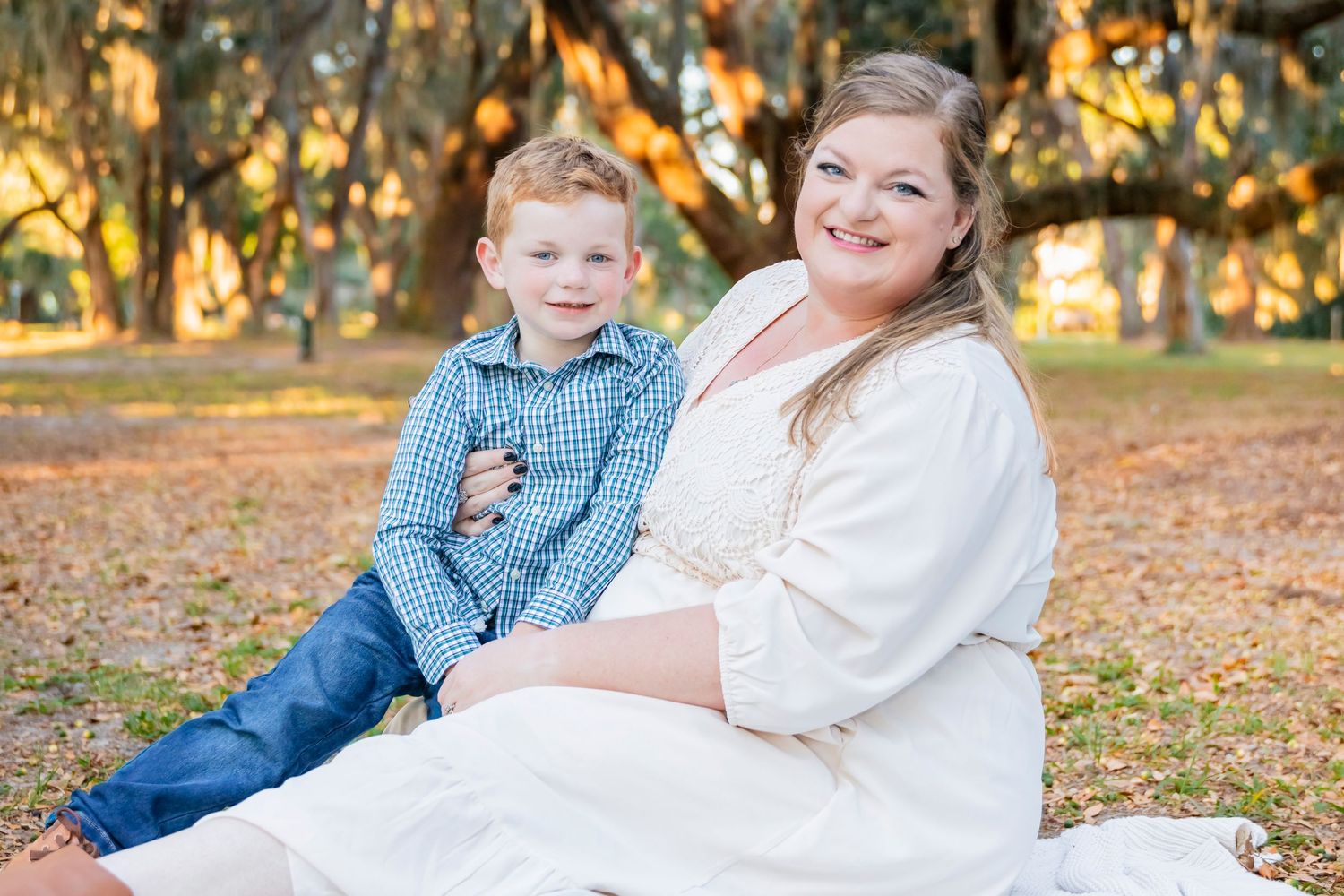 Maternity portrait session in autumn park with falling leaves.