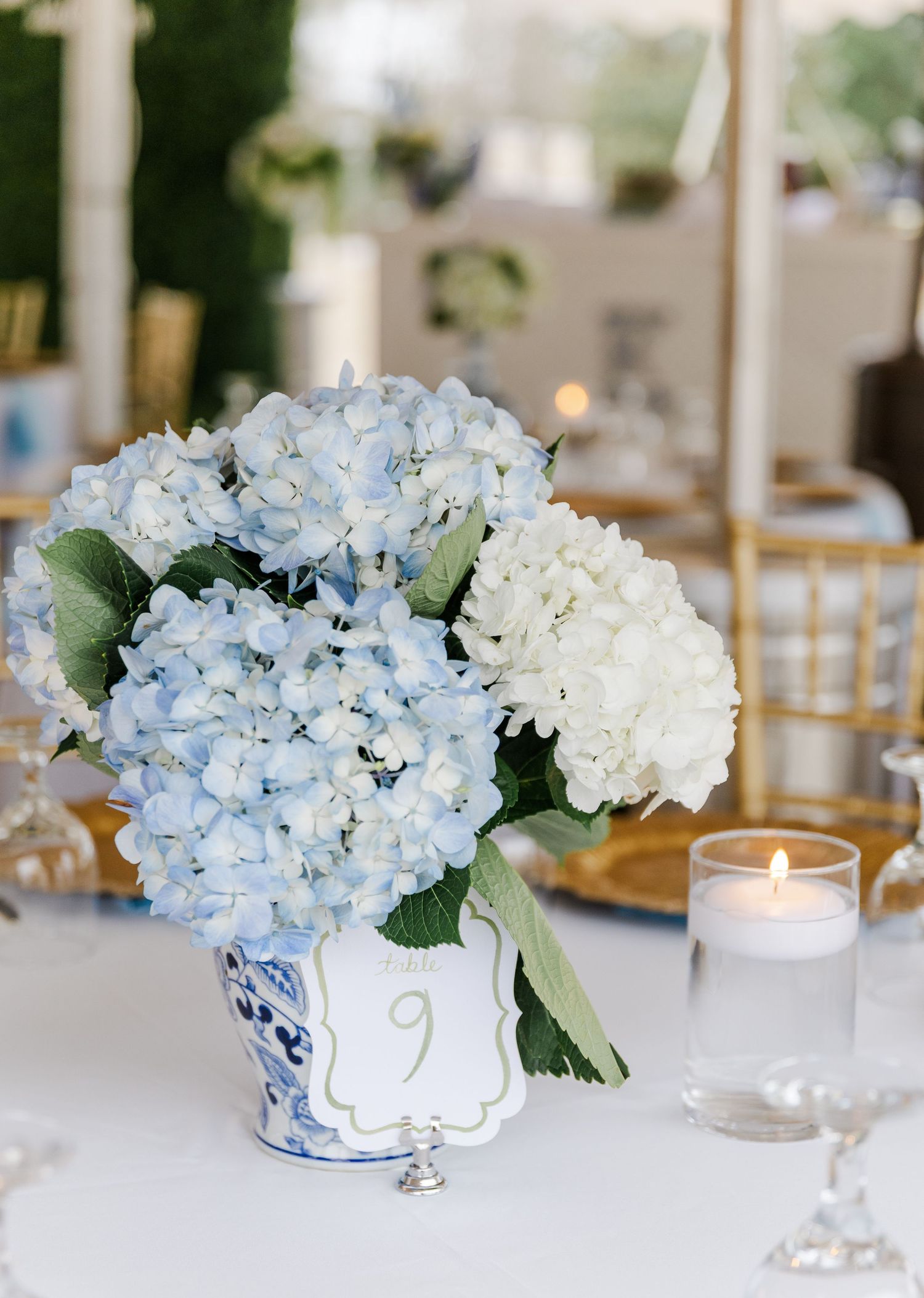 Blue and white hydrangea centerpiece in chinoiserie vase with table number nine.