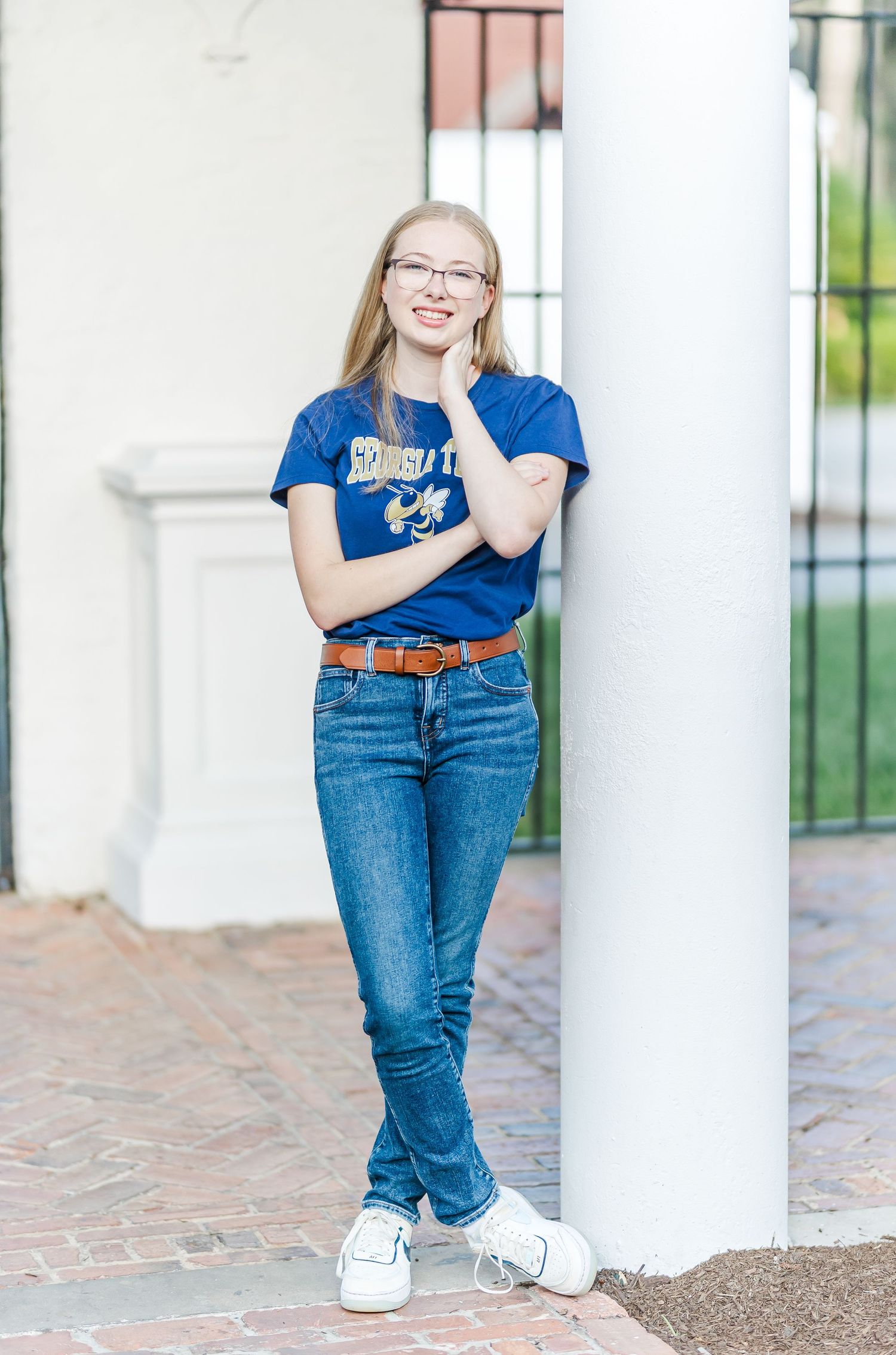 A series of casual portraits in front of white columns showing poses in blue t-shirt and jeans.