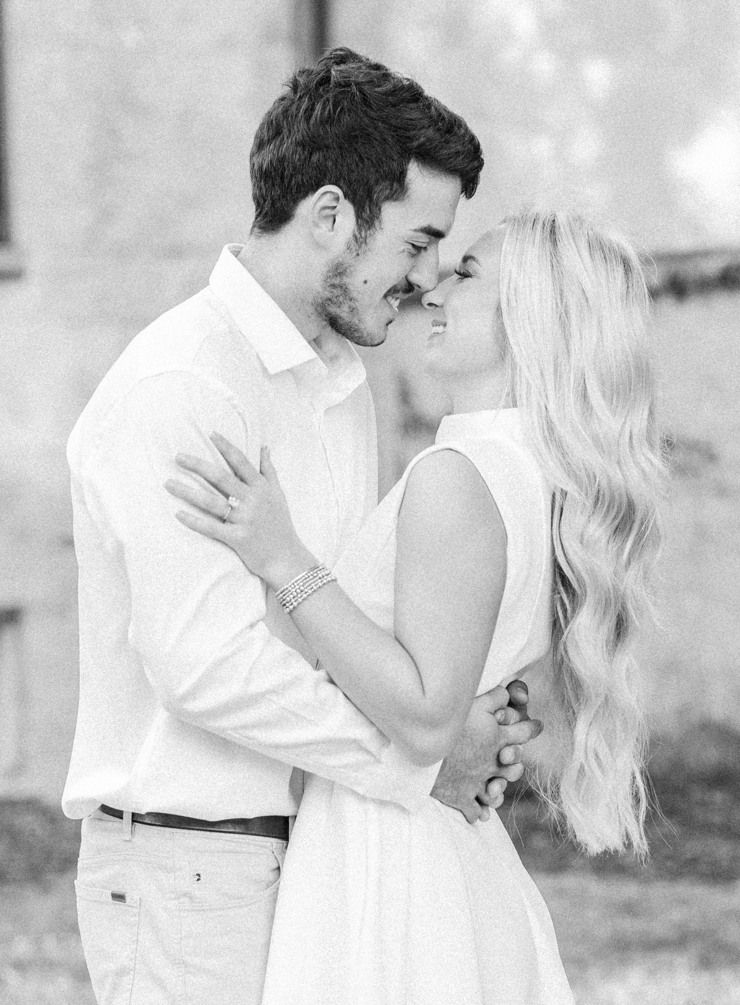 A romantic black and white photo series showing a couple embracing and kissing in an outdoor setting.