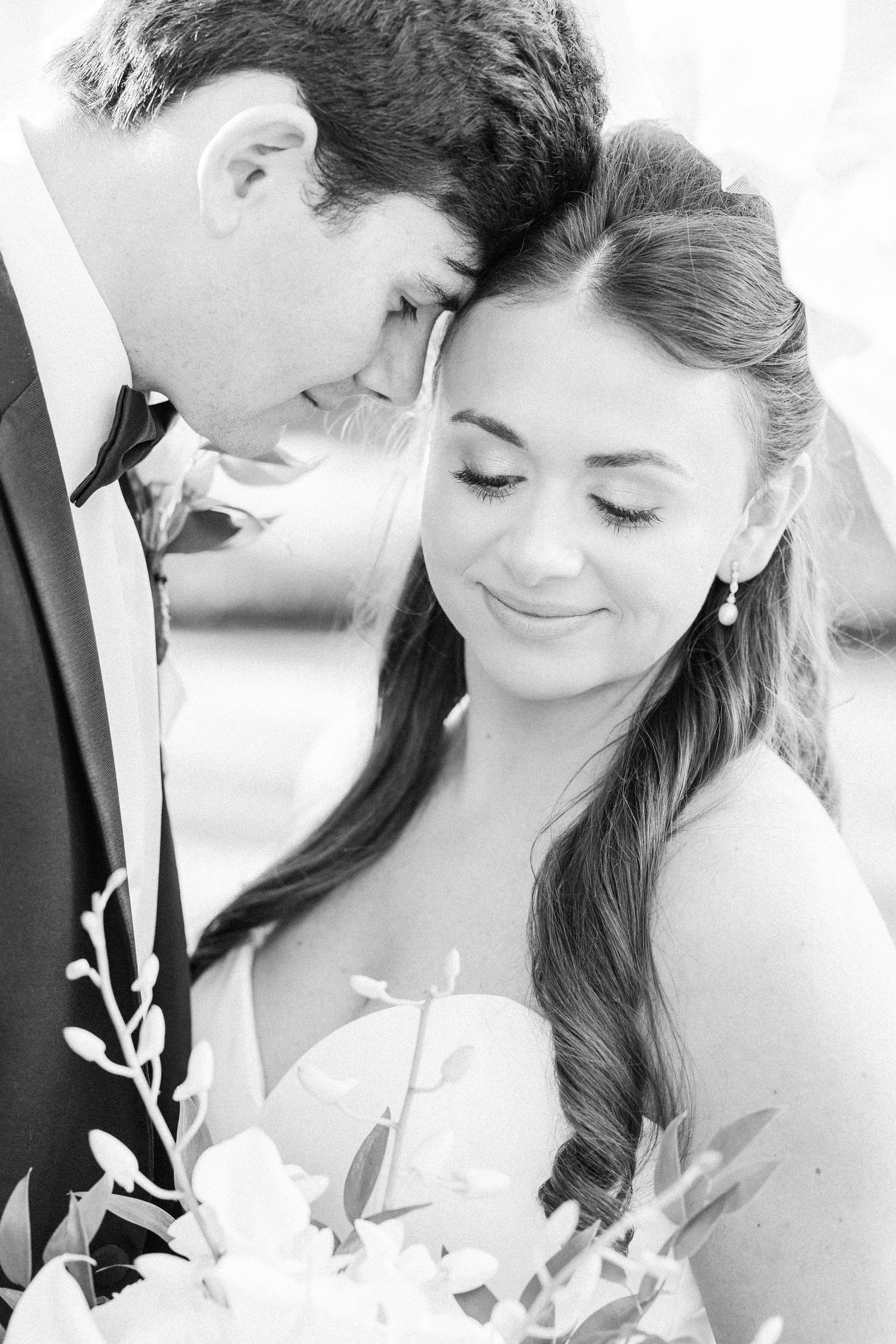 Black and white close-up sequence showing romantic moments between a couple in wedding attire.