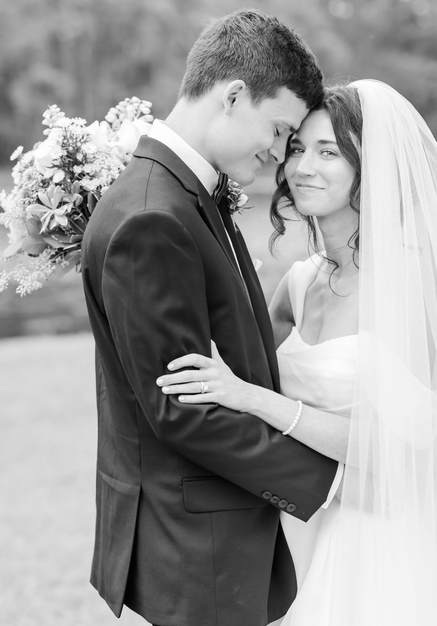 Black and white wedding portraits showing intimate moments between newlyweds in an outdoor garden setting.