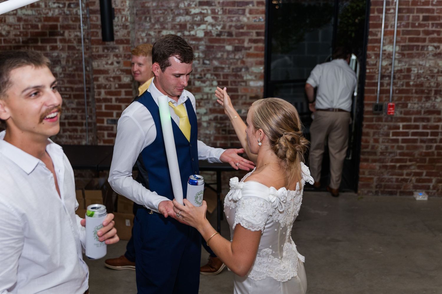 Wedding reception celebration in rustic brick venue with dancing and festivities.