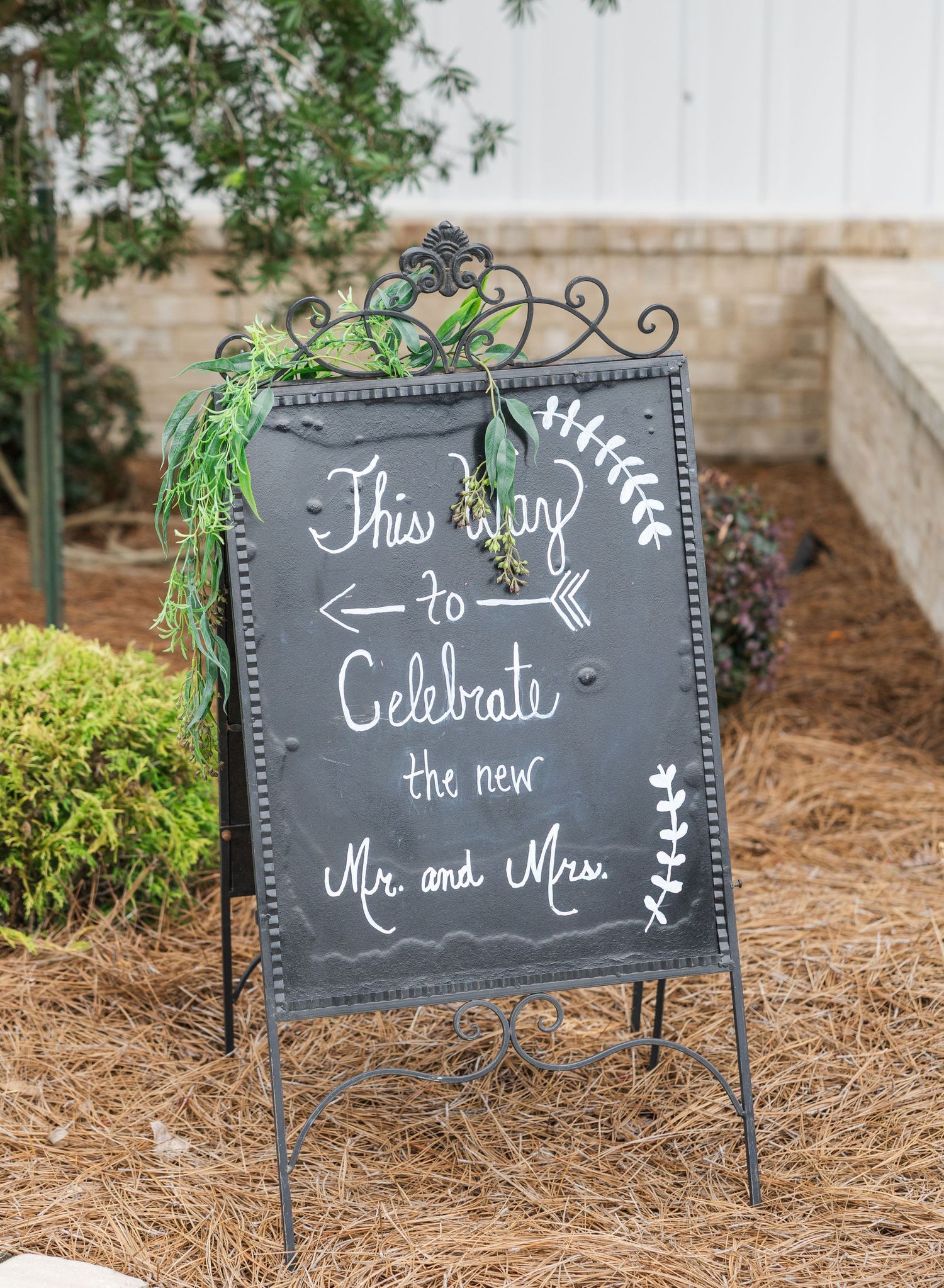 Decorative chalkboard wedding sign reading This Way to Celebrate the new Mr. and Mrs. with arrow design.