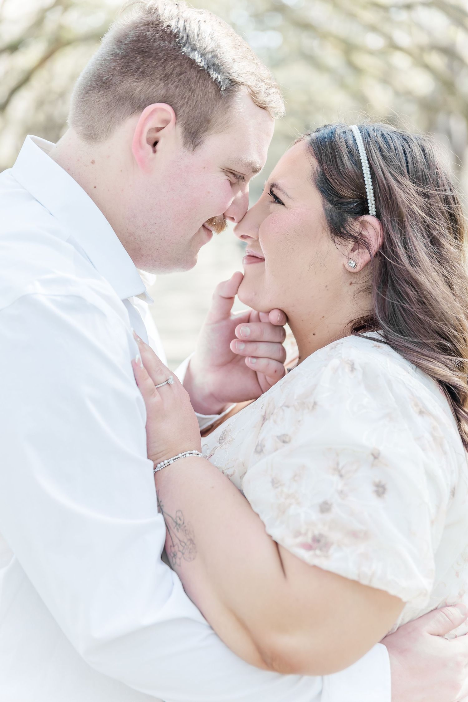 Intimate moment between couple sharing a tender embrace during outdoor photo session.