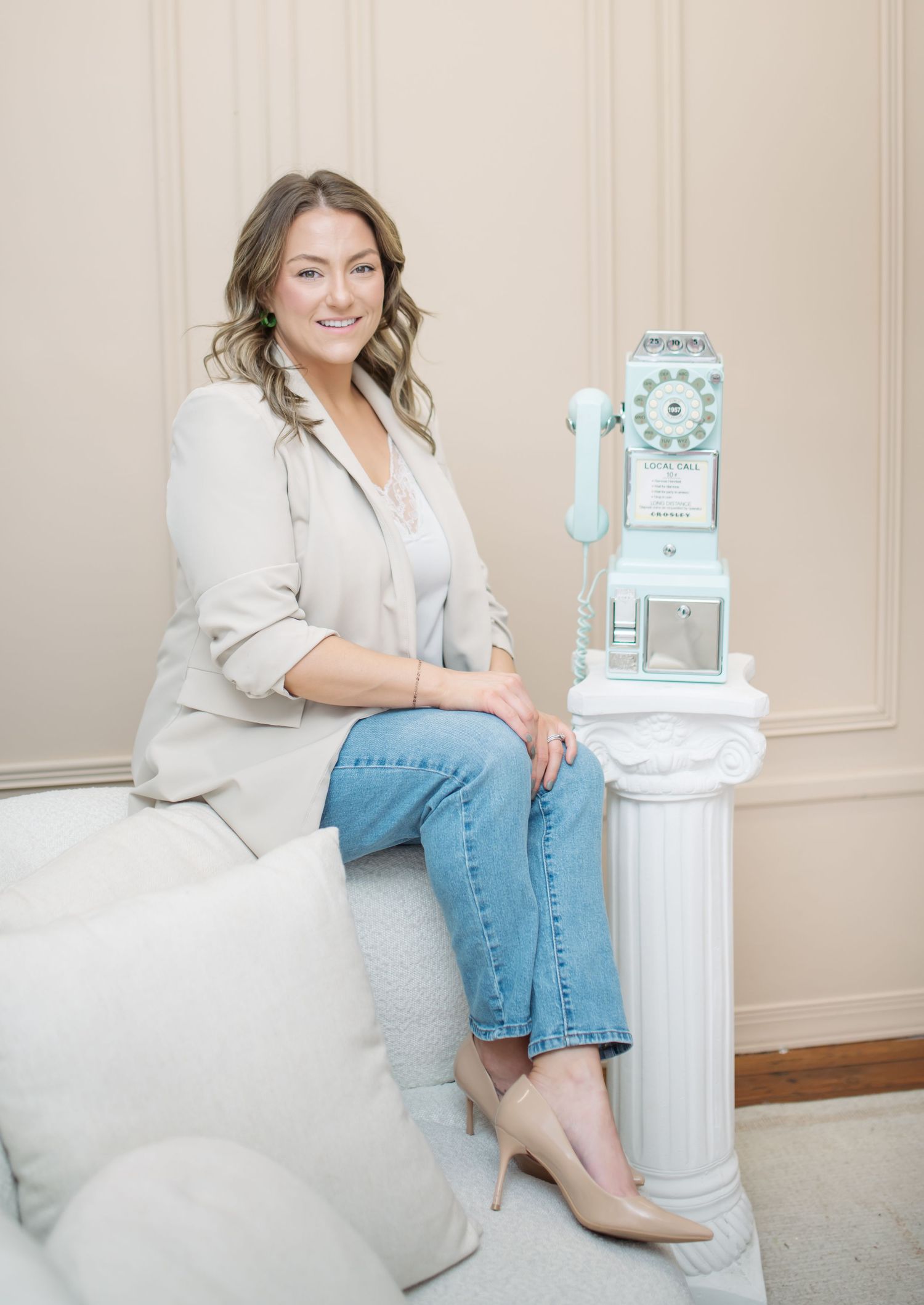 Professional lifestyle photo series showing person in white shirt and jeans sitting beside decorative white column against neutral wall.