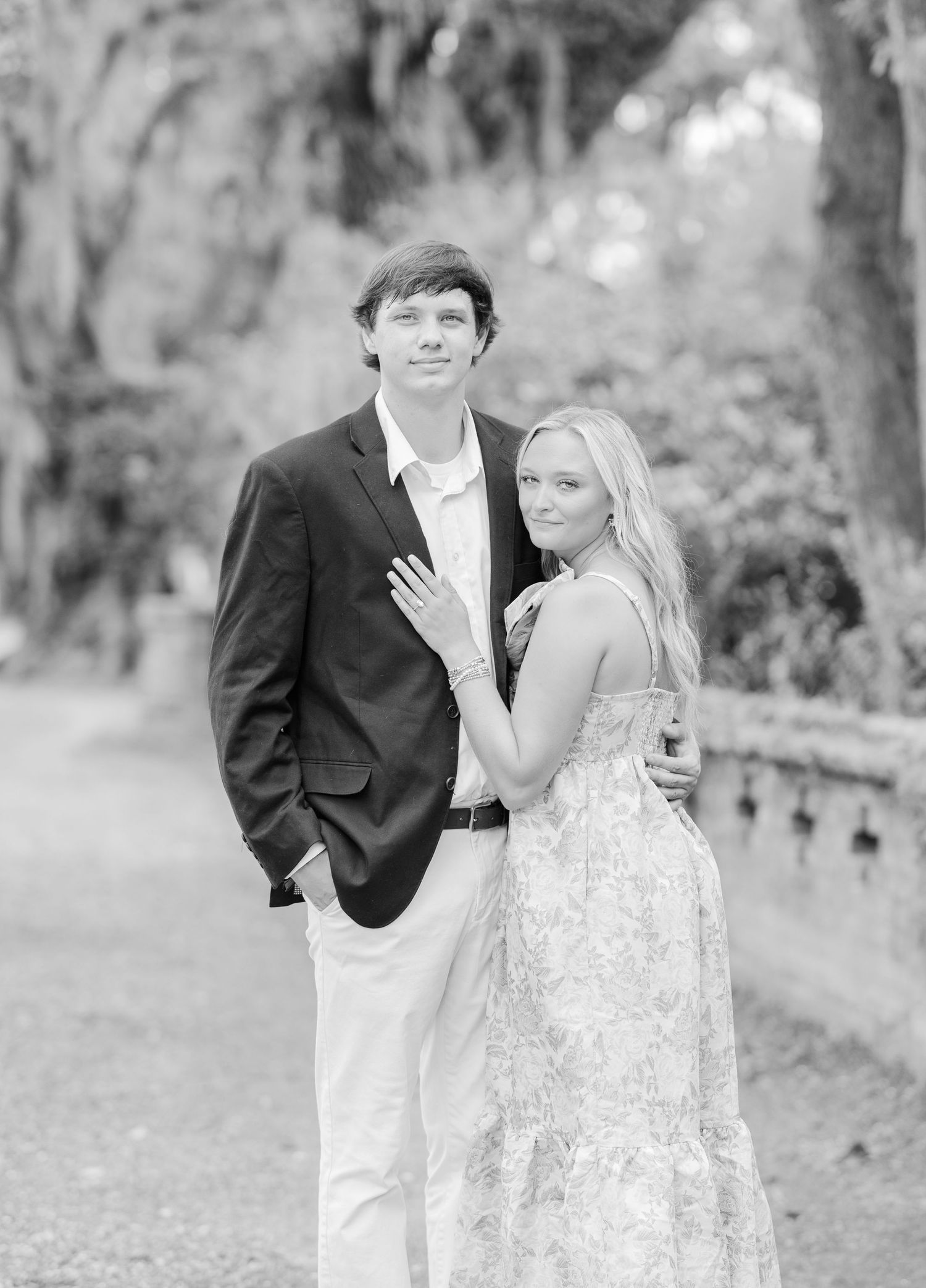 Black and white portrait series of a couple in formal attire posing in a natural outdoor setting.