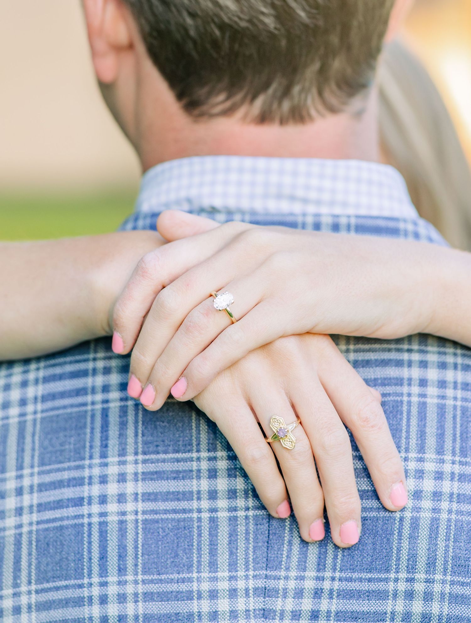 Close-up shots of hands wearing engagement rings against a blue plaid shirt background.