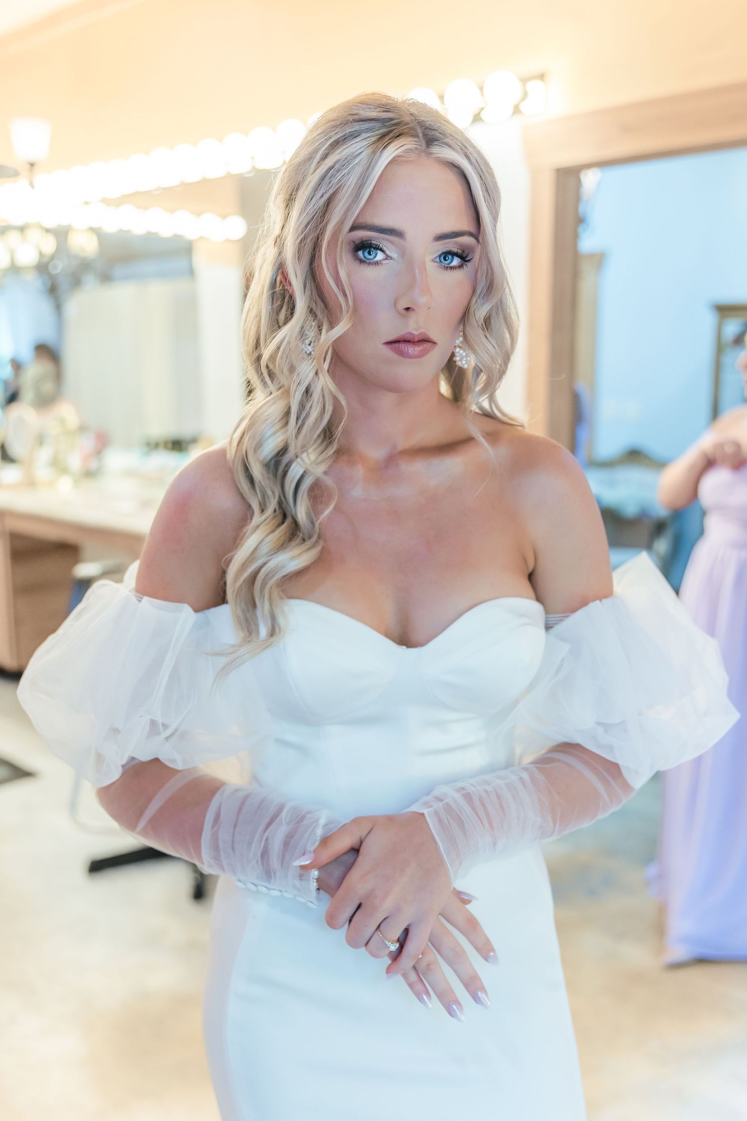 A wedding dress fitting scene in a bridal boutique with a sweetheart neckline and sheer sleeves.