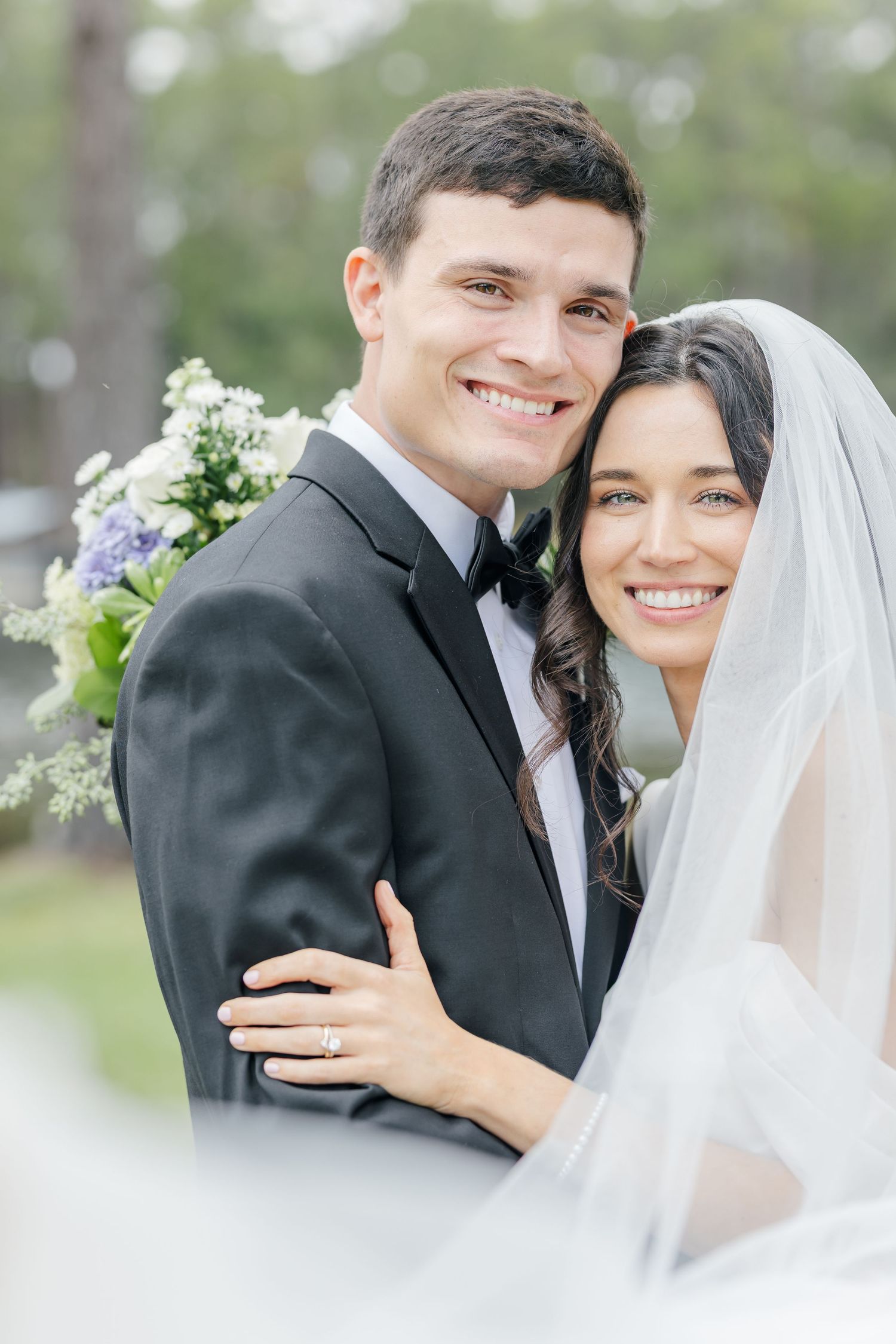 A bride and groom share intimate moments in a series of romantic wedding portraits outdoors.
