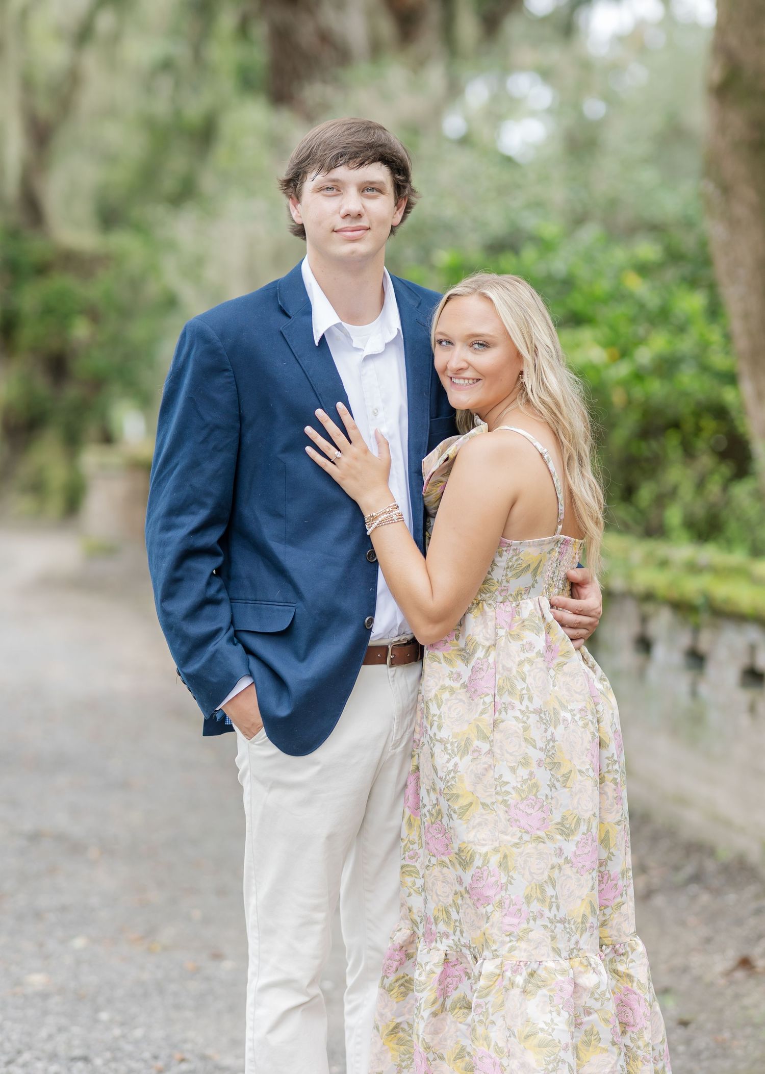 Couple in coordinated spring outfits share playful moments in a lush garden setting.