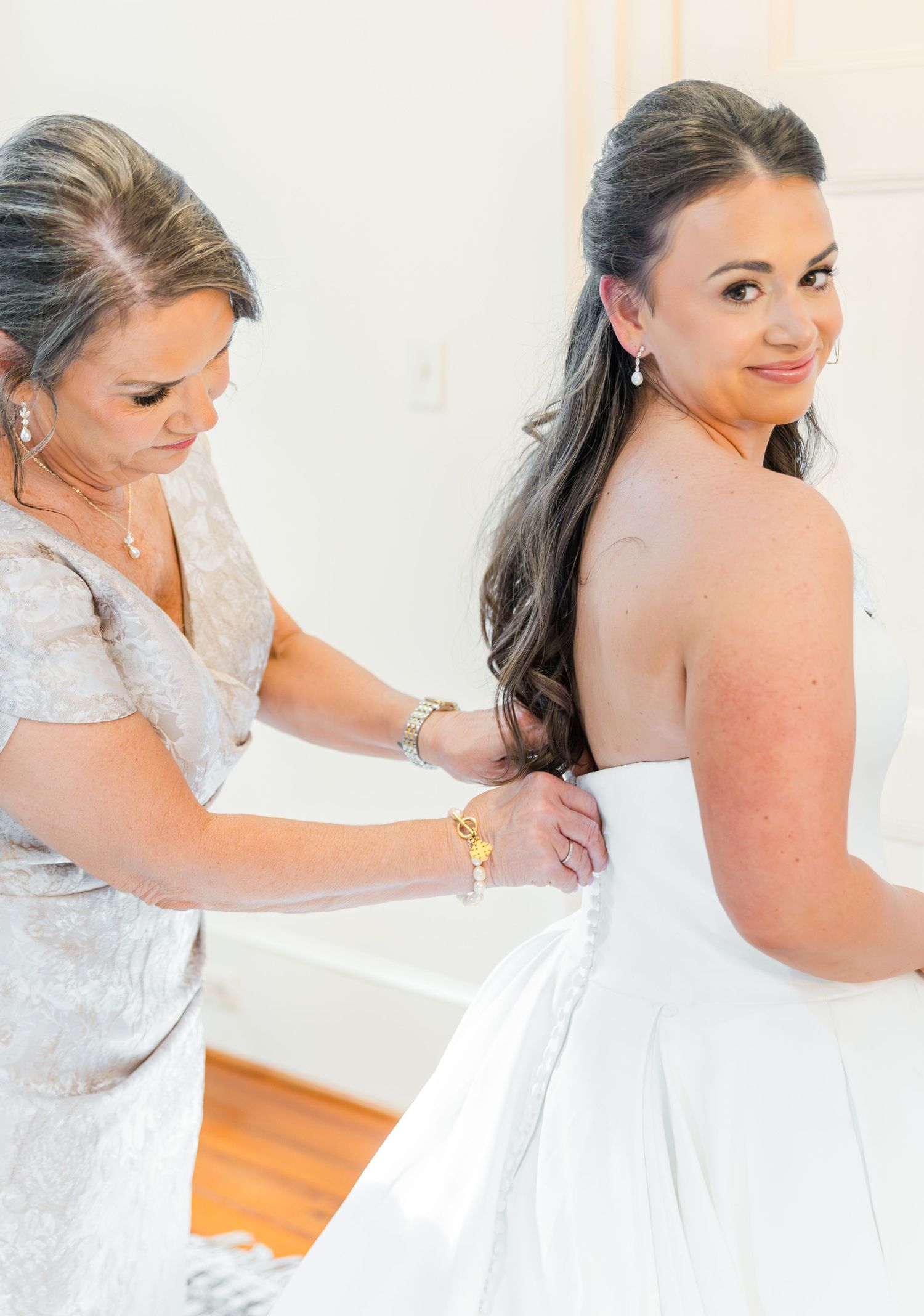 A series of photos showing someone getting dressed in a white wedding gown with lace details.