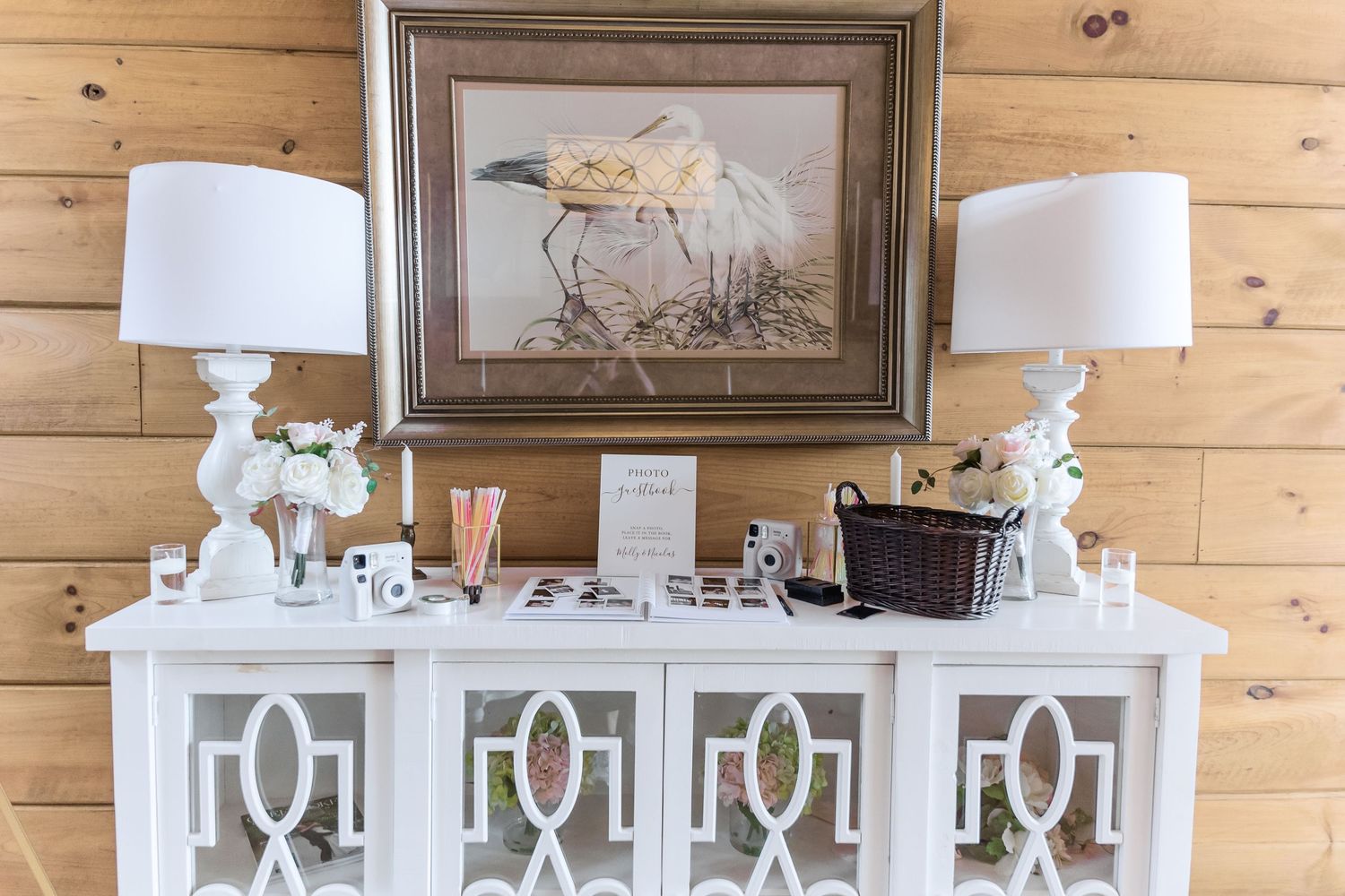 Elegant white console table with matching lamps and framed artwork in rustic wood interior.