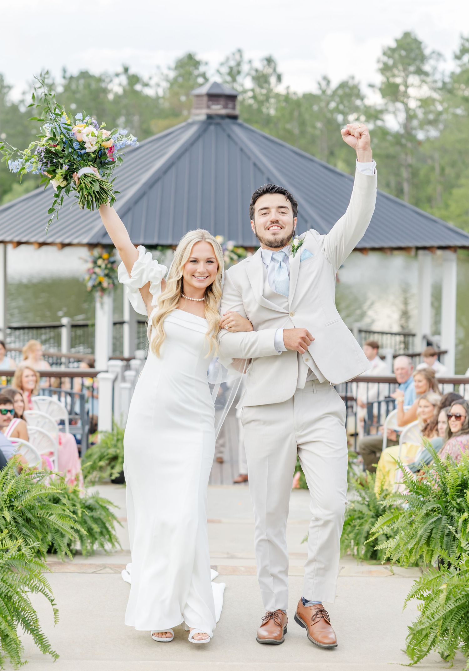 Joyful newlyweds celebrate walking back down the aisle after their outdoor gazebo wedding.
