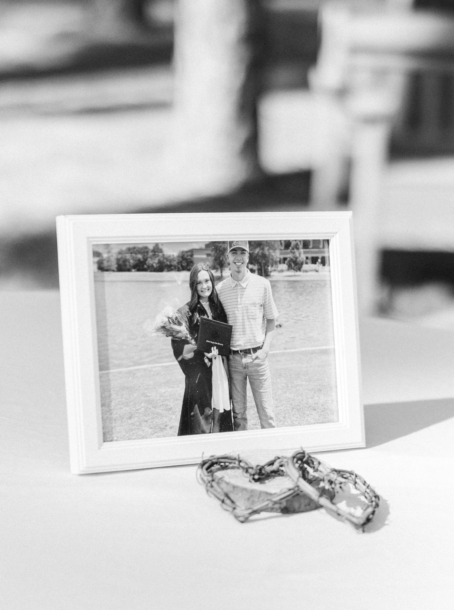 Black and white framed photo of a couple displayed on a table with decorative oyster shell hearts.