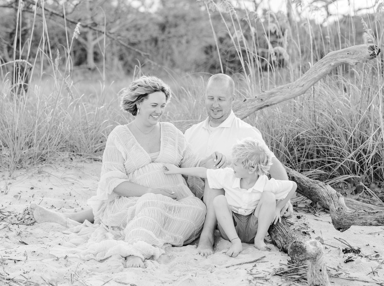 Black and white family beach portraits with natural coastal elements.