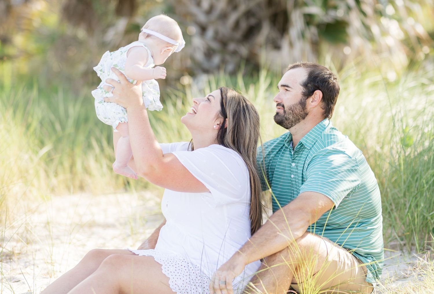 A couple in casual attire shares playful moments together in a sunny outdoor setting.