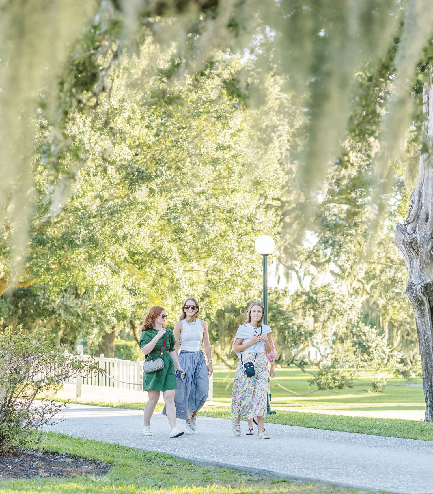 A couple walks together on a winding path through a scenic park on a sunny autumn day.