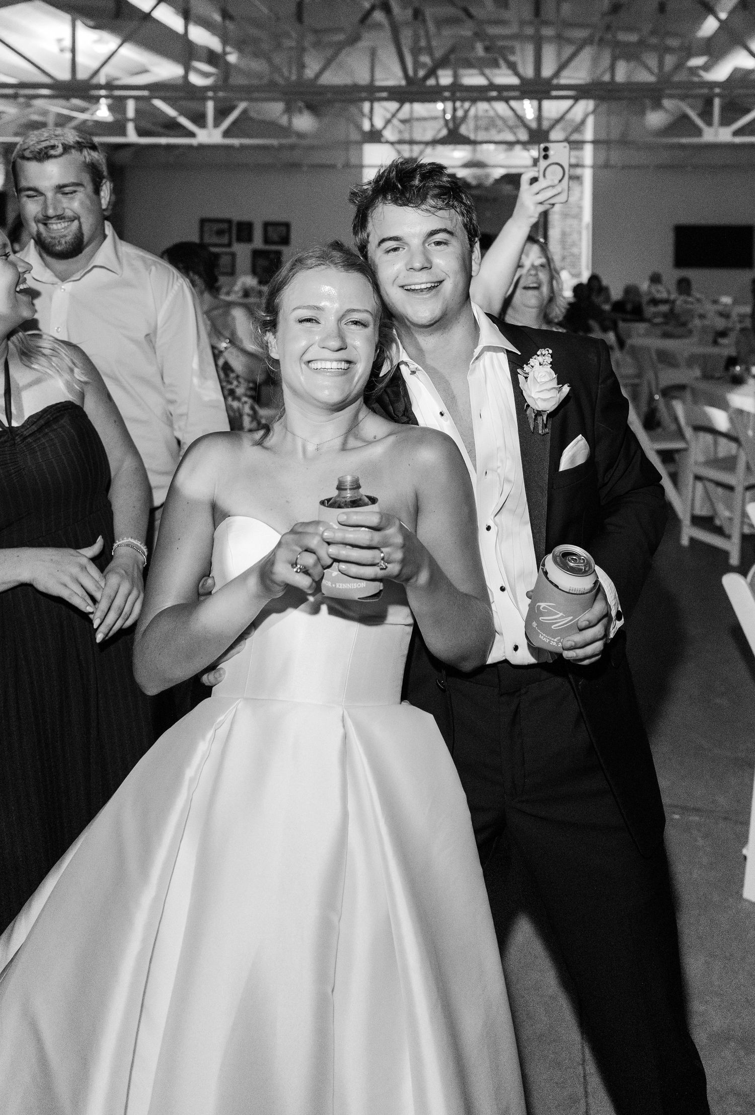 Black and white photo of smiling bride and groom celebrating together on the dance floor.